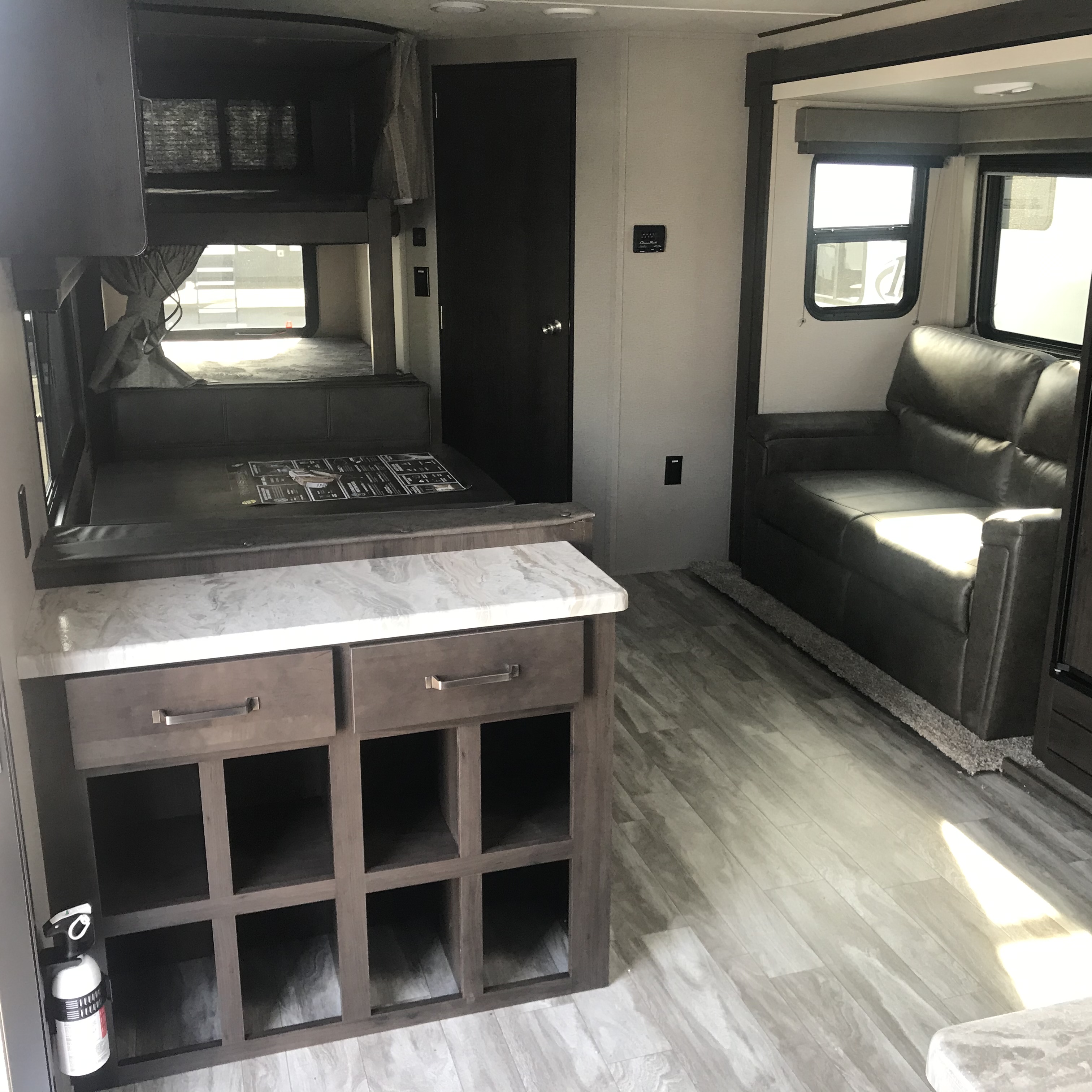Explore this RV rental's cozy interior: bunk beds, kitchen island, and comfortable living room sofa.. Grand Design Transcend 261BH 2021