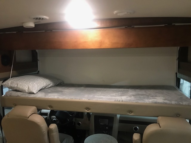 Comfortable overhead sleeping area in an RV rental, overlooking the driver's seat and dashboard.. Forest River Georgetown 3 Series 30X3 2017