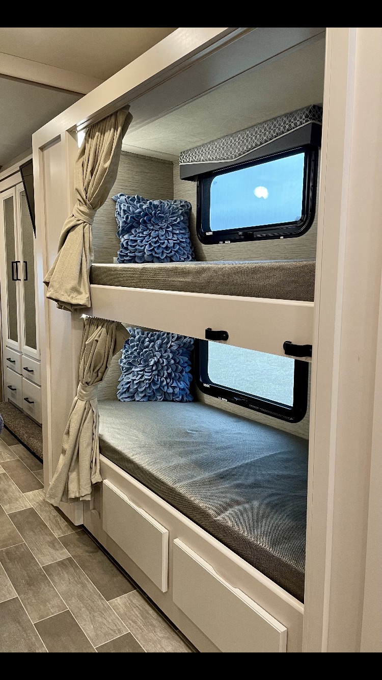 Modern RV rental bunk beds feature cozy mattresses, windows, privacy curtains, and lower storage.. Thor Motor Coach Chateau 2021