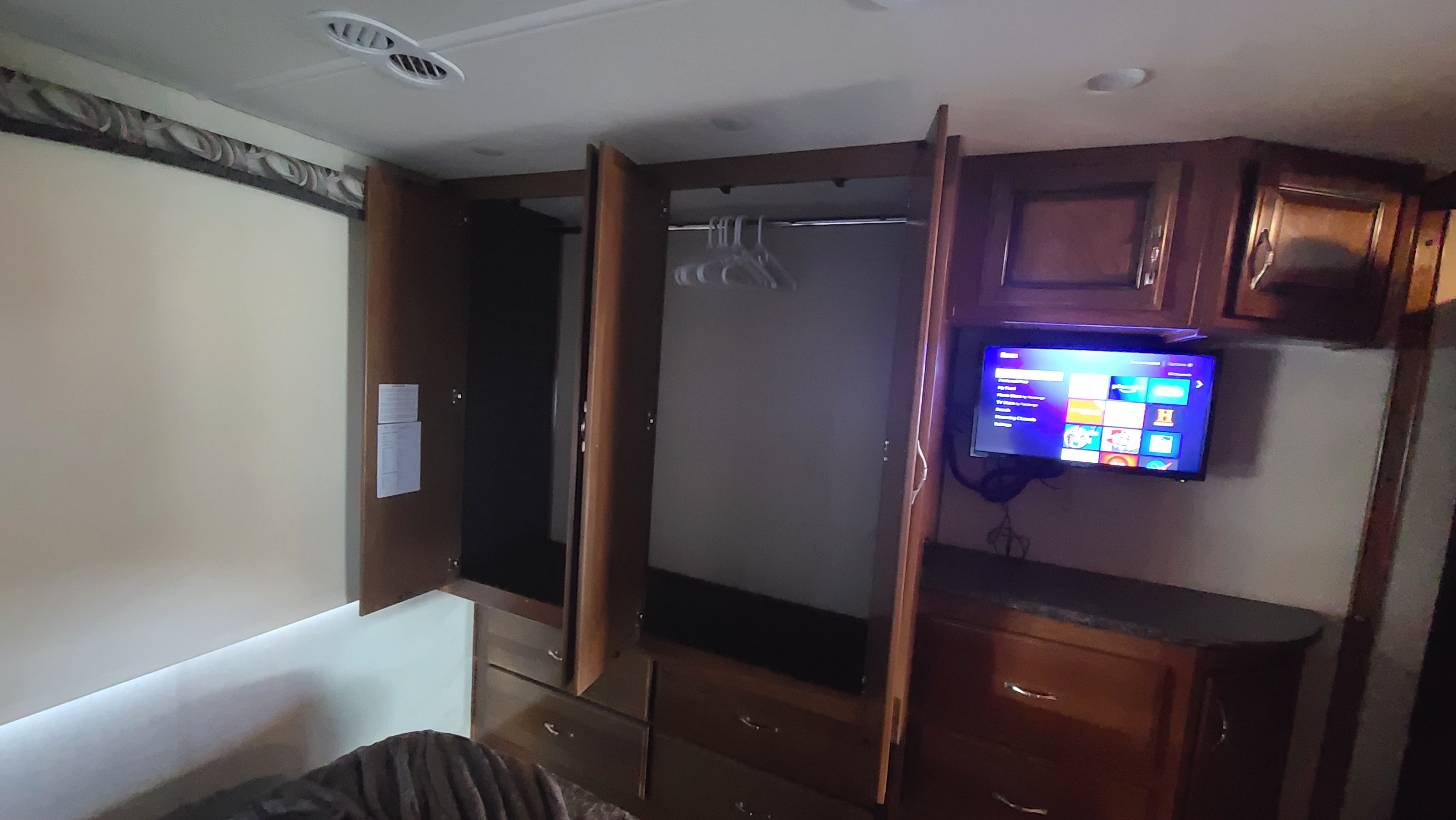 This RV rental offers storage: a wardrobe with hangers, dresser, and a mounted TV in the bedroom area.. Fleetwood Flair 2017