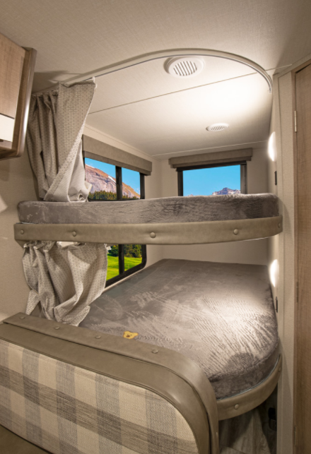 Inside your RV rental, find cozy bunk beds with privacy curtains and scenic views for comfortable family camping.. Grand Design Imagine XLS 2021