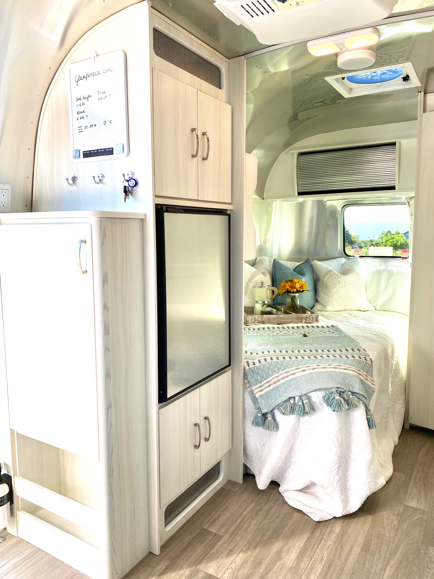 Cozy Airstream RV rental interior features a comfy bed, modern kitchenette, and organized space. Perfect for glamping adventures!. Airstream Bambi 2021