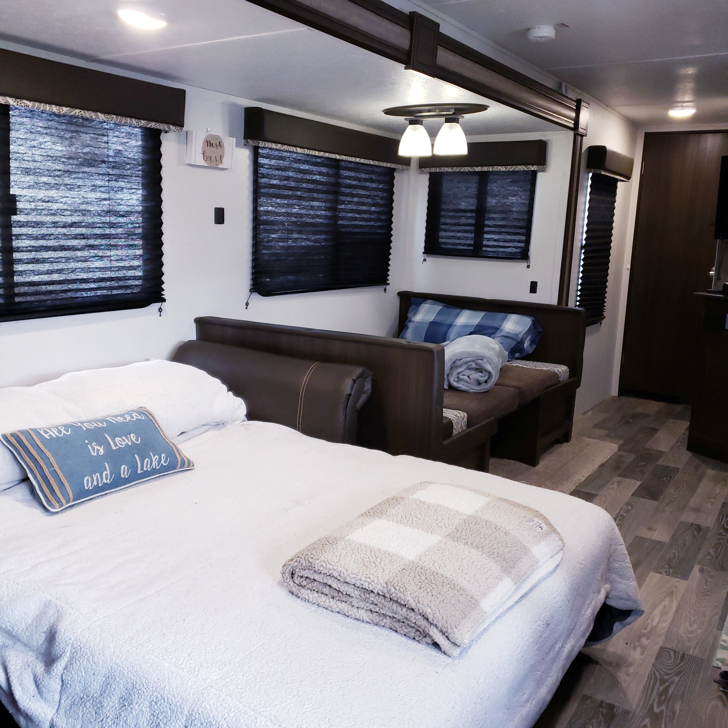 Cozy RV rental interior with a comfortable bed, dining area, and dark blinds for privacy. Ideal for a relaxing trip.. Keystone Springdale 2020