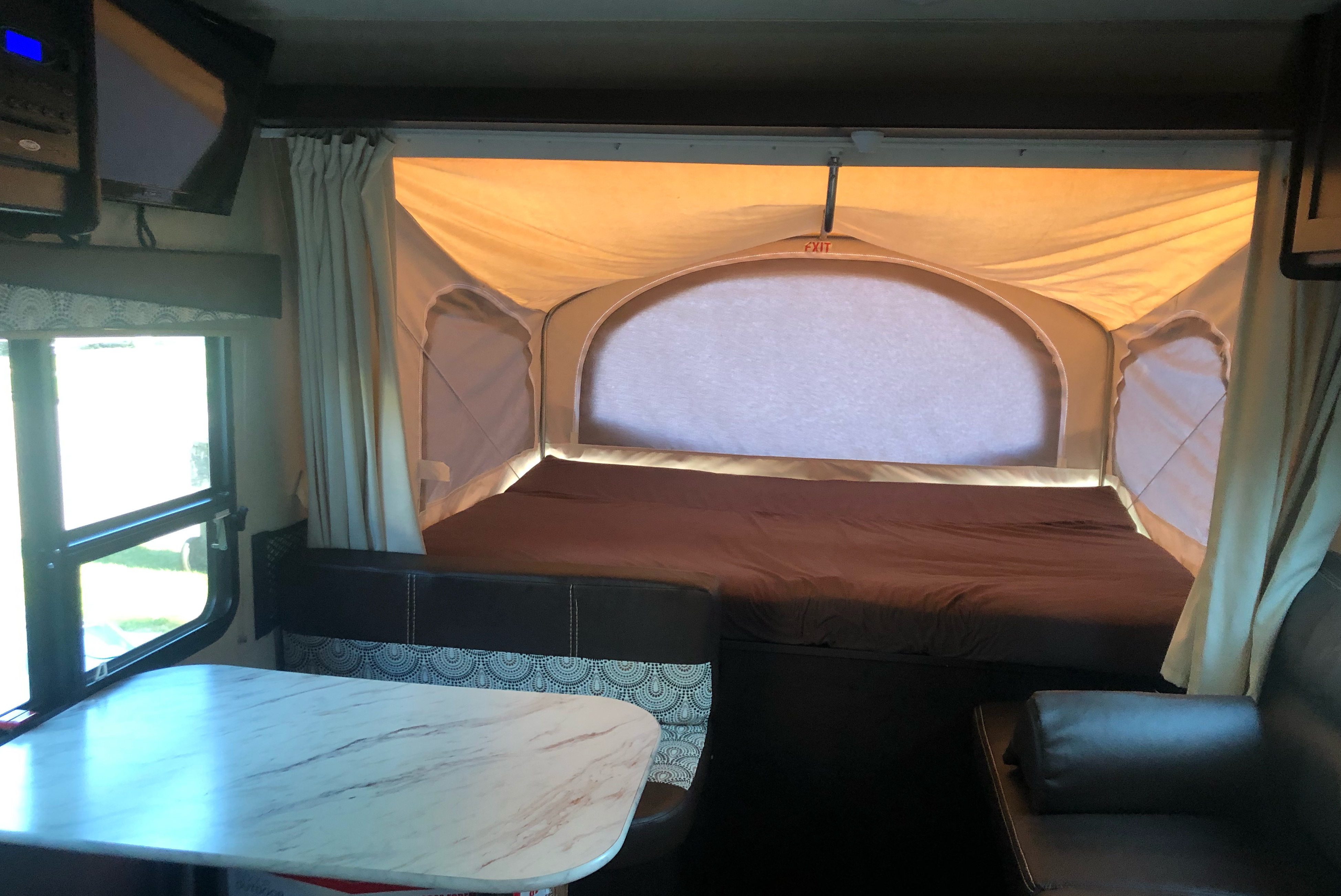 Spacious rv rental interior features a cozy pop-out bed, dinette, and living space for comfortable travel.. Dutchmen Kodiak Express 2016