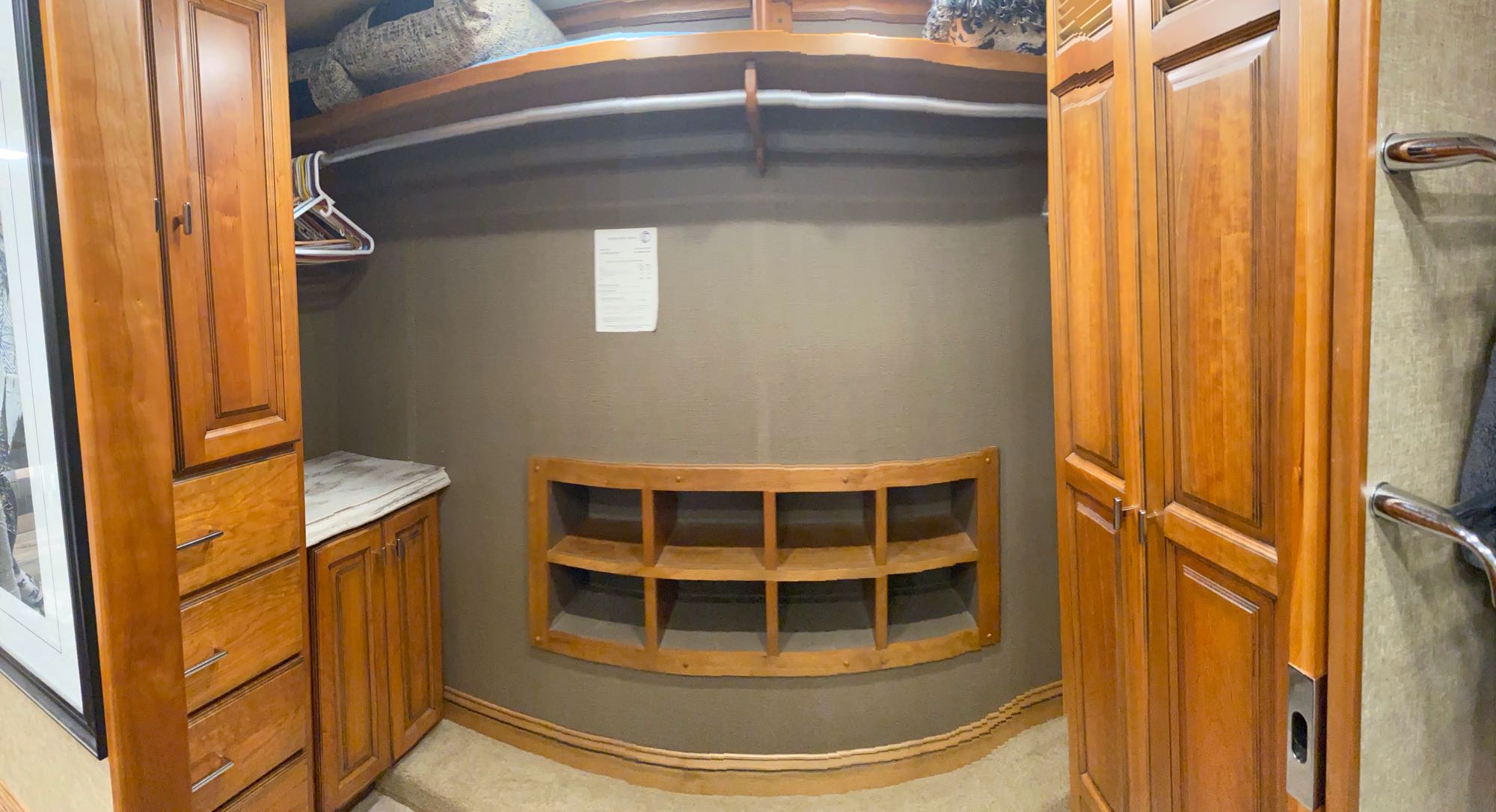 Explore this organized RV rental closet: wood cabinetry, hanging rod, built-in shoe rack, and drawers.. Tiffin Motorhomes Allegro Bus 2018