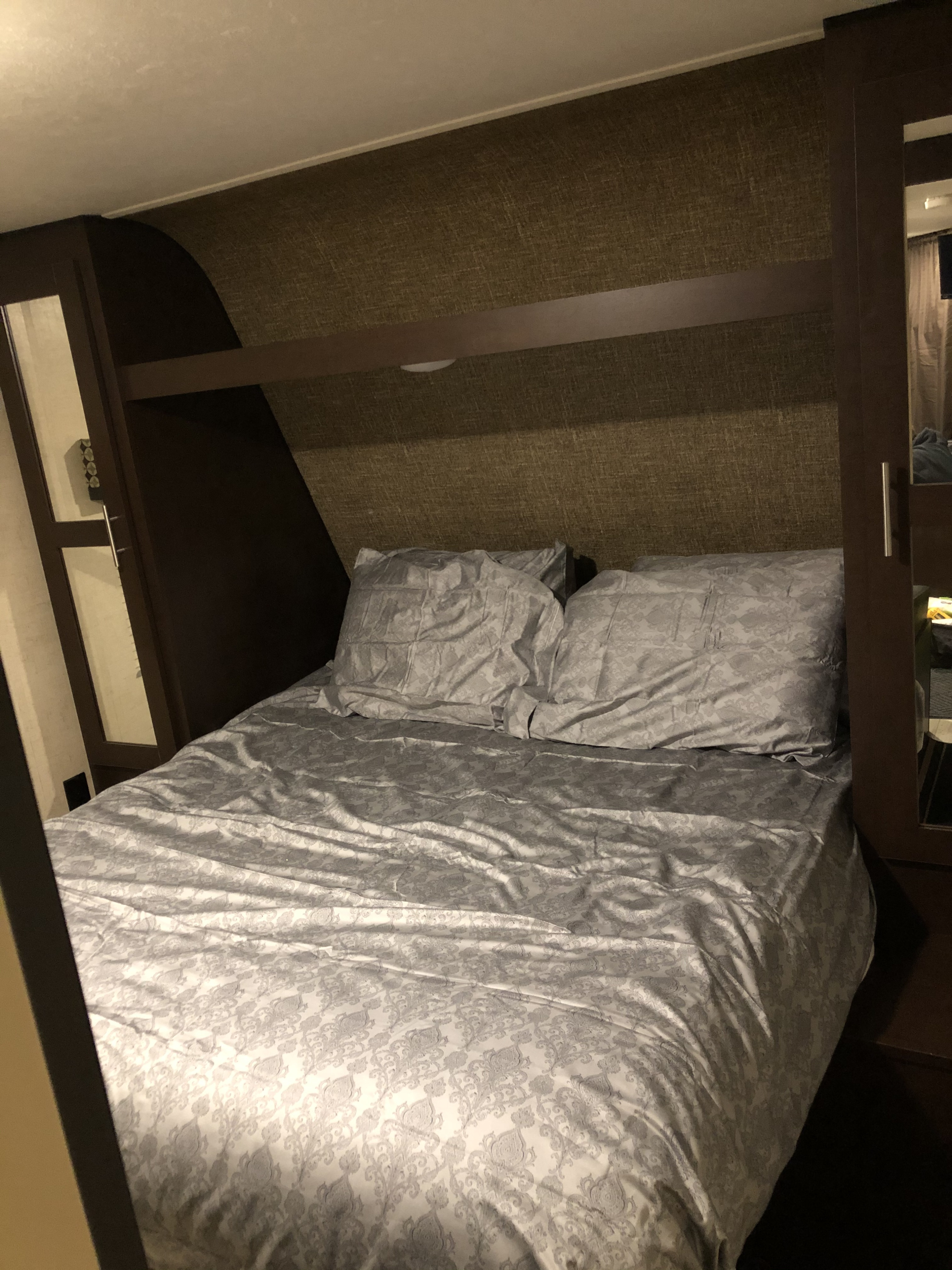 Cozy RV rental bedroom with a neatly made bed, grey patterned bedding, and built-in storage.. Other Other 2017