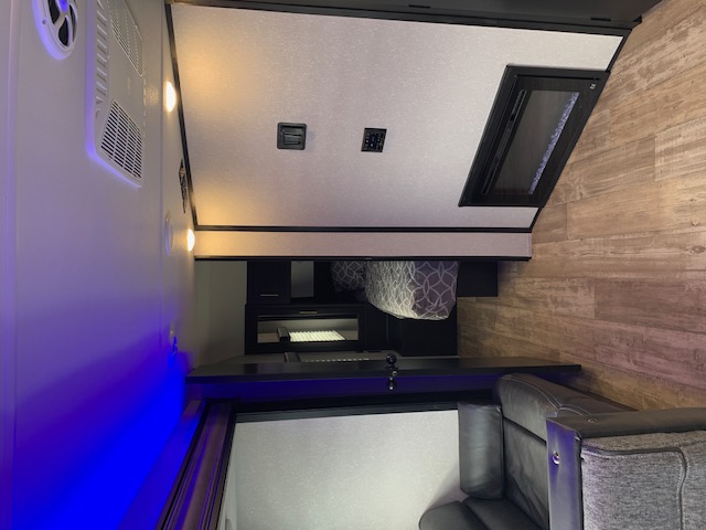 Spacious RV rental interior with a comfy bed, modern blue & white lighting, and durable wood-look flooring.. Cherokee Grey Wolf 27DBH 2021