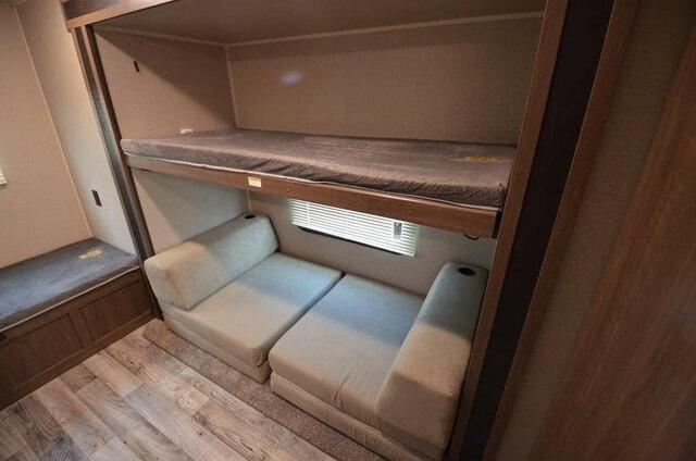 RV rental interior: practical bunk bed setup, lower bunk converts to seating, plus additional bench seating on left.. Keystone Hideout 2020