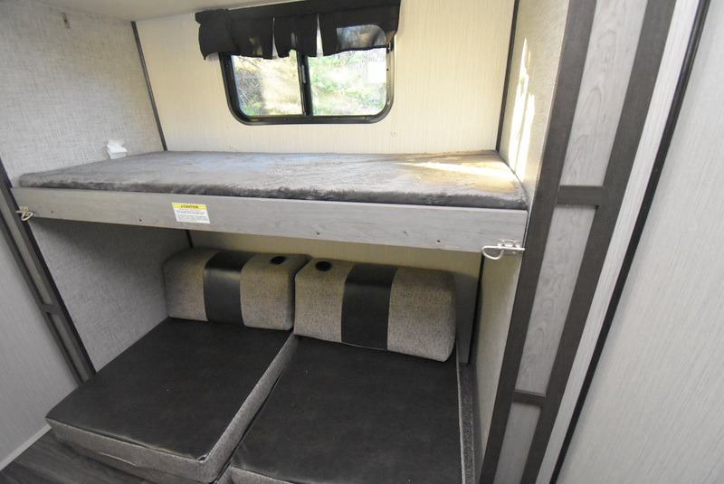 Compact RV rental interior featuring a comfy top bunk bed and versatile lower seating, ideal for travel adventures.. Other M-3385 2020
