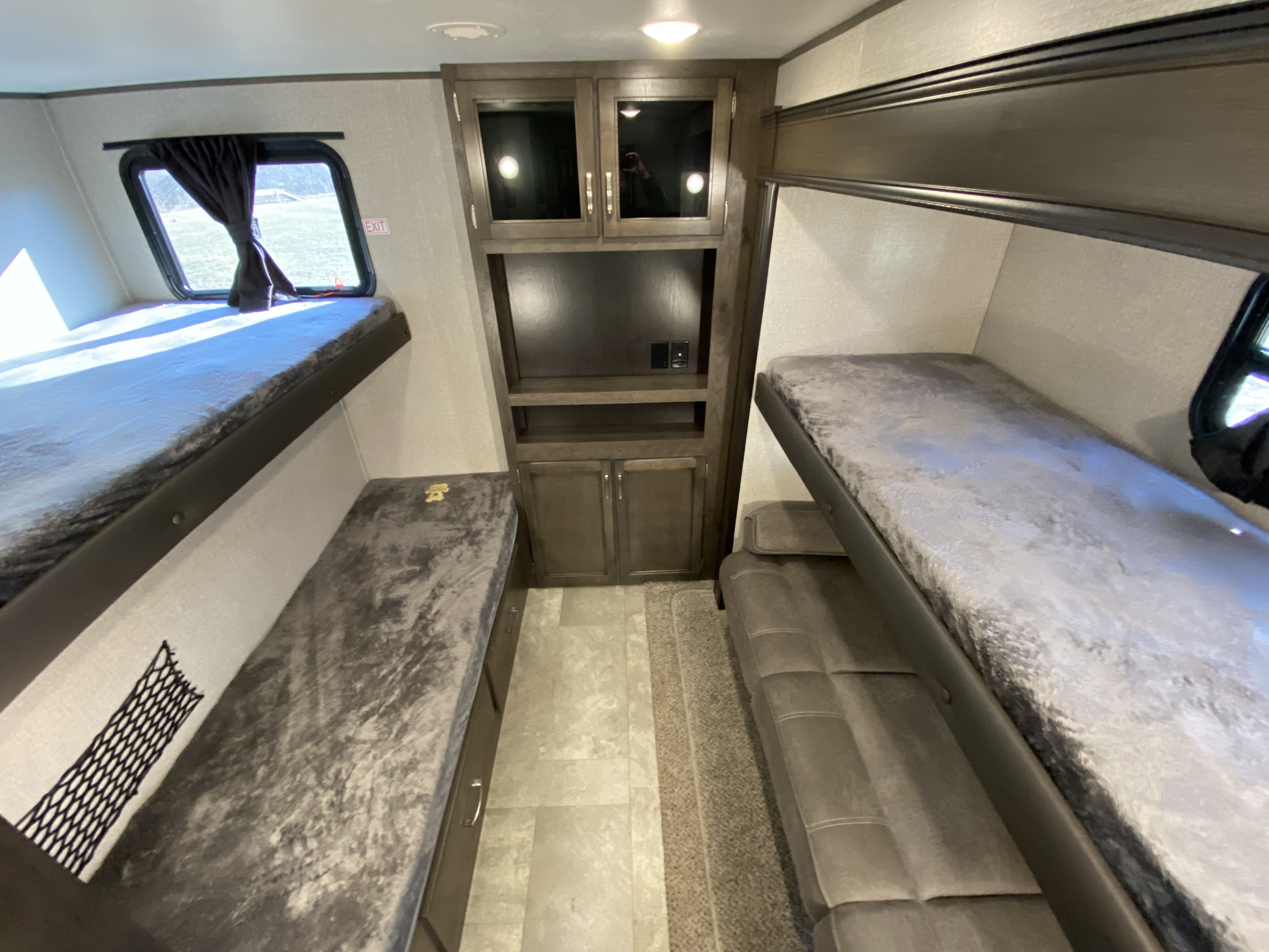 RV rental: Interior shows two sets of bunk beds, central storage/entertainment, window, and a lower bunk convertible sofa.. Jayco Jay Flight 2021