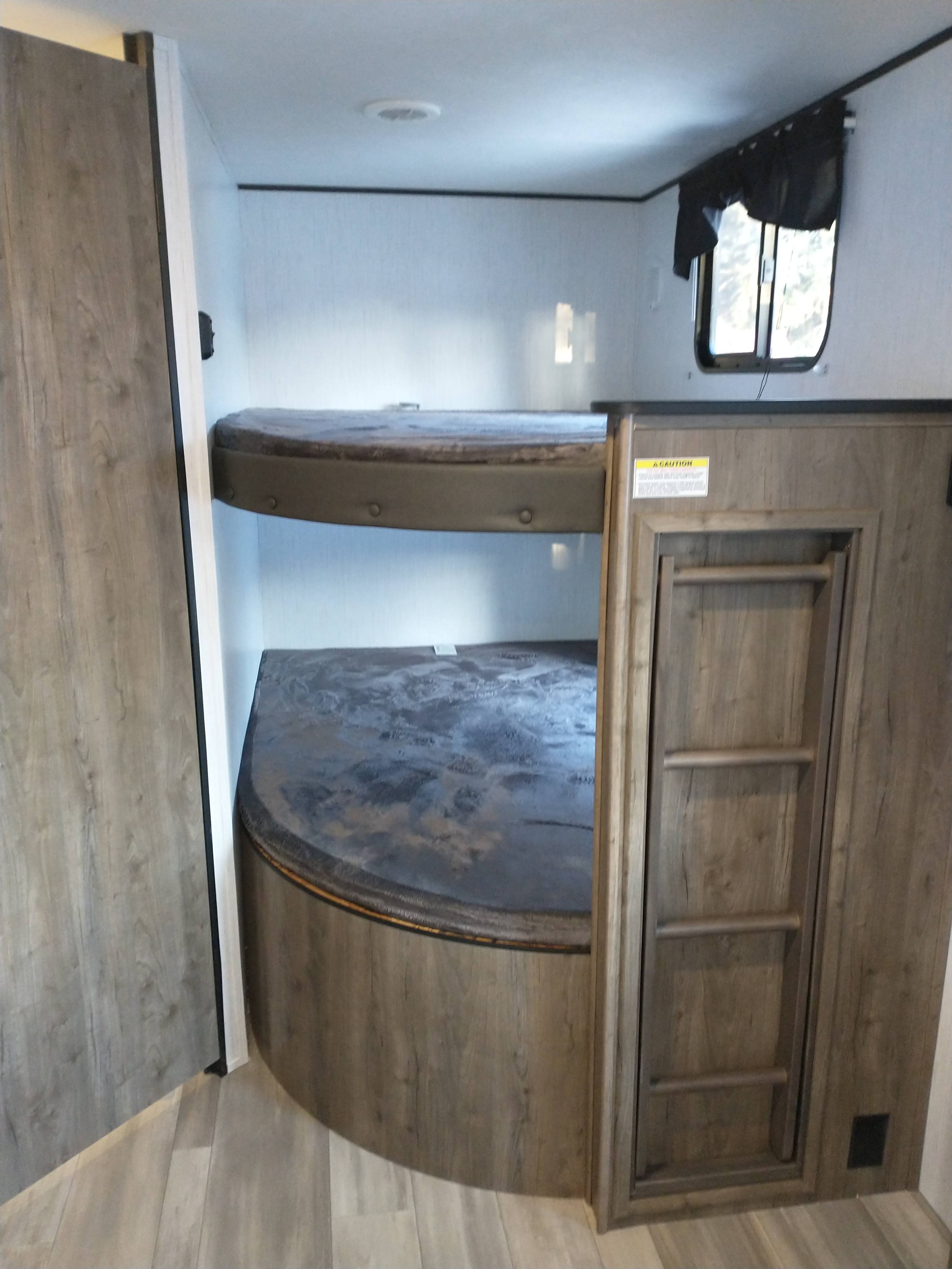 RV rental with cozy bunk beds on two levels, featuring a ladder and wood-paneled interior, perfect for families.. Heartland Pioneer 2021