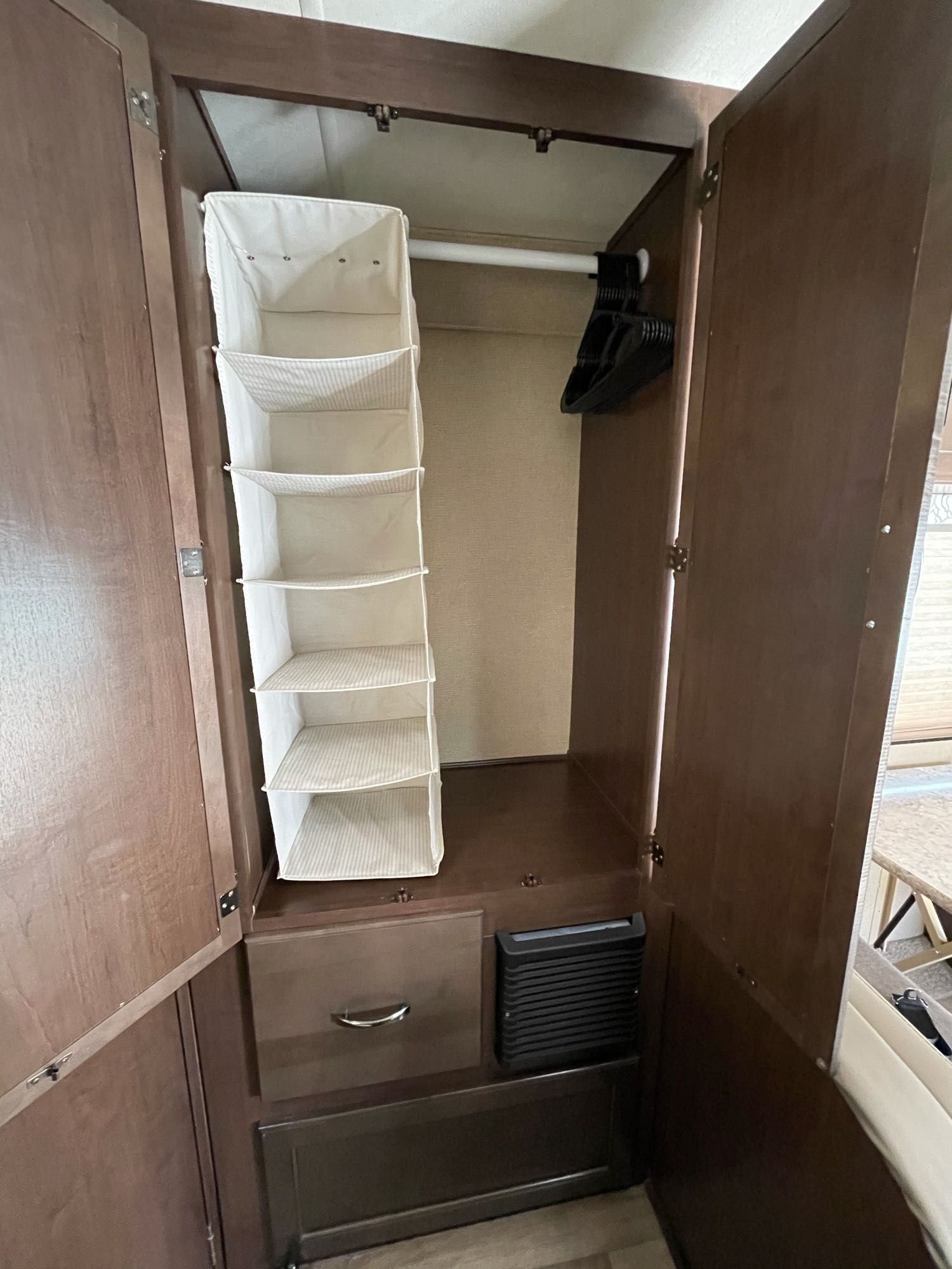 Maximize space in your RV rental with this compact wardrobe, featuring a hanging organizer and drawer for efficient storage.. Thor Freedom Elite 2019