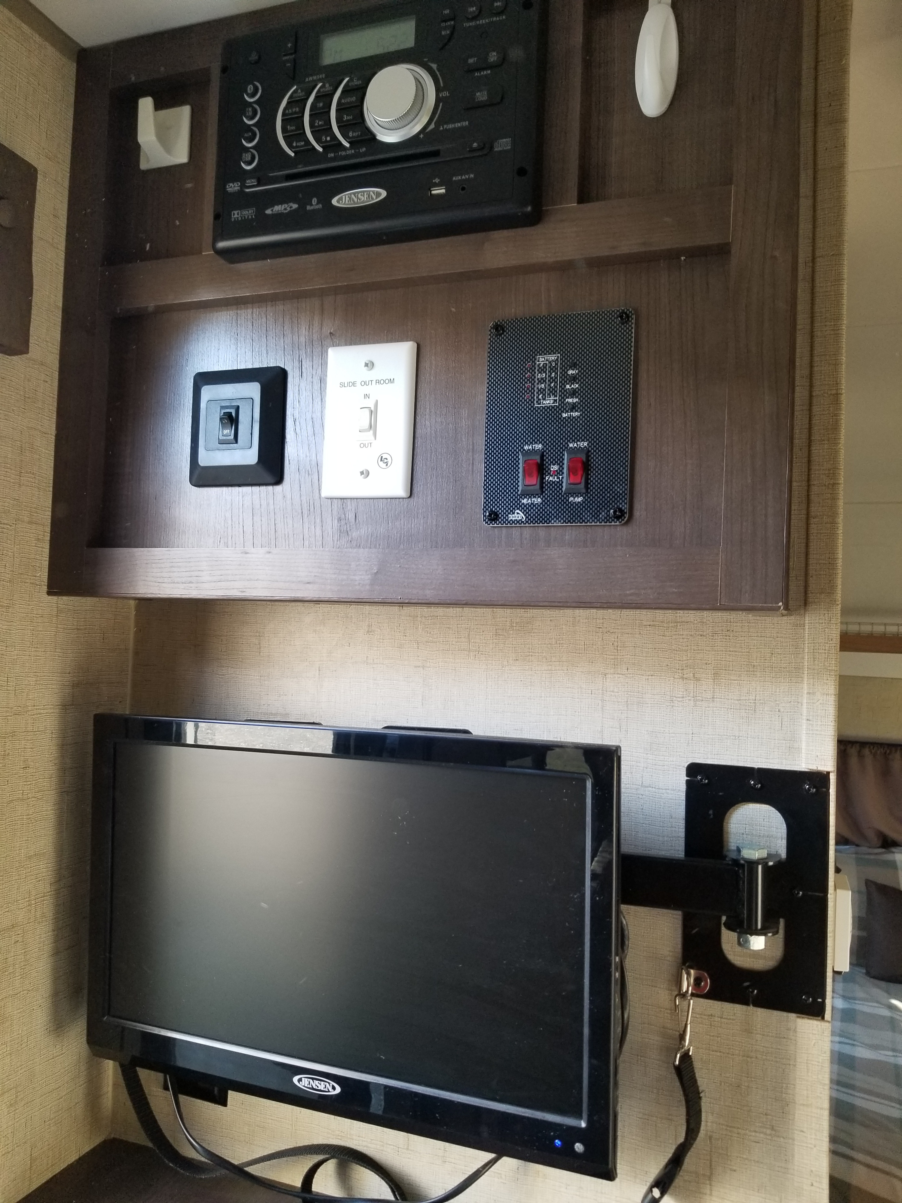 RV rental interior: Jensen entertainment system, RV control panel for slide-out/water/tanks, and a mounted TV.. Forest River R-Pod 2016