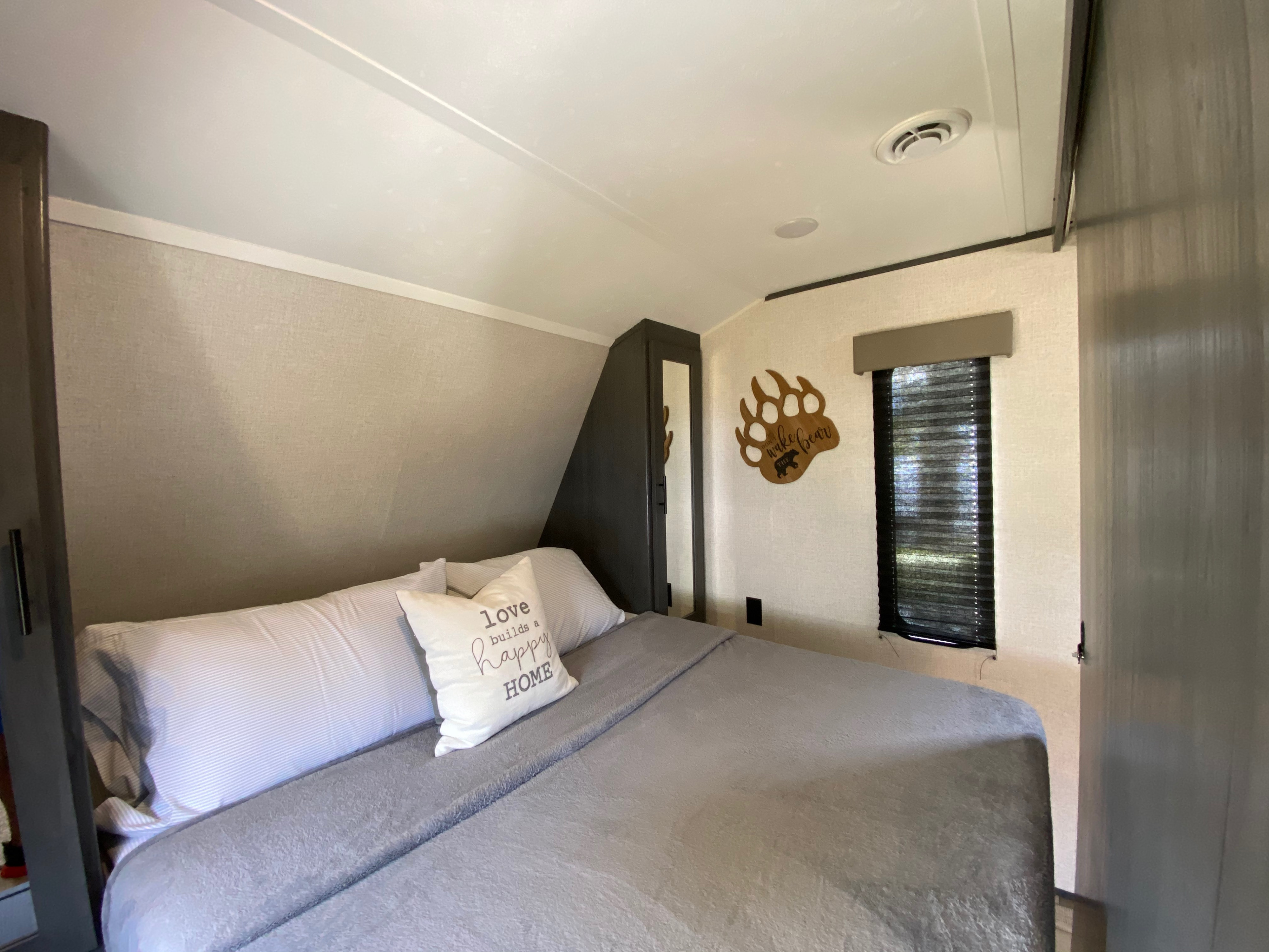 Cozy RV rental bedroom with bear decor, ready for a restful night.. Dutchmen Aspen Trail 2021