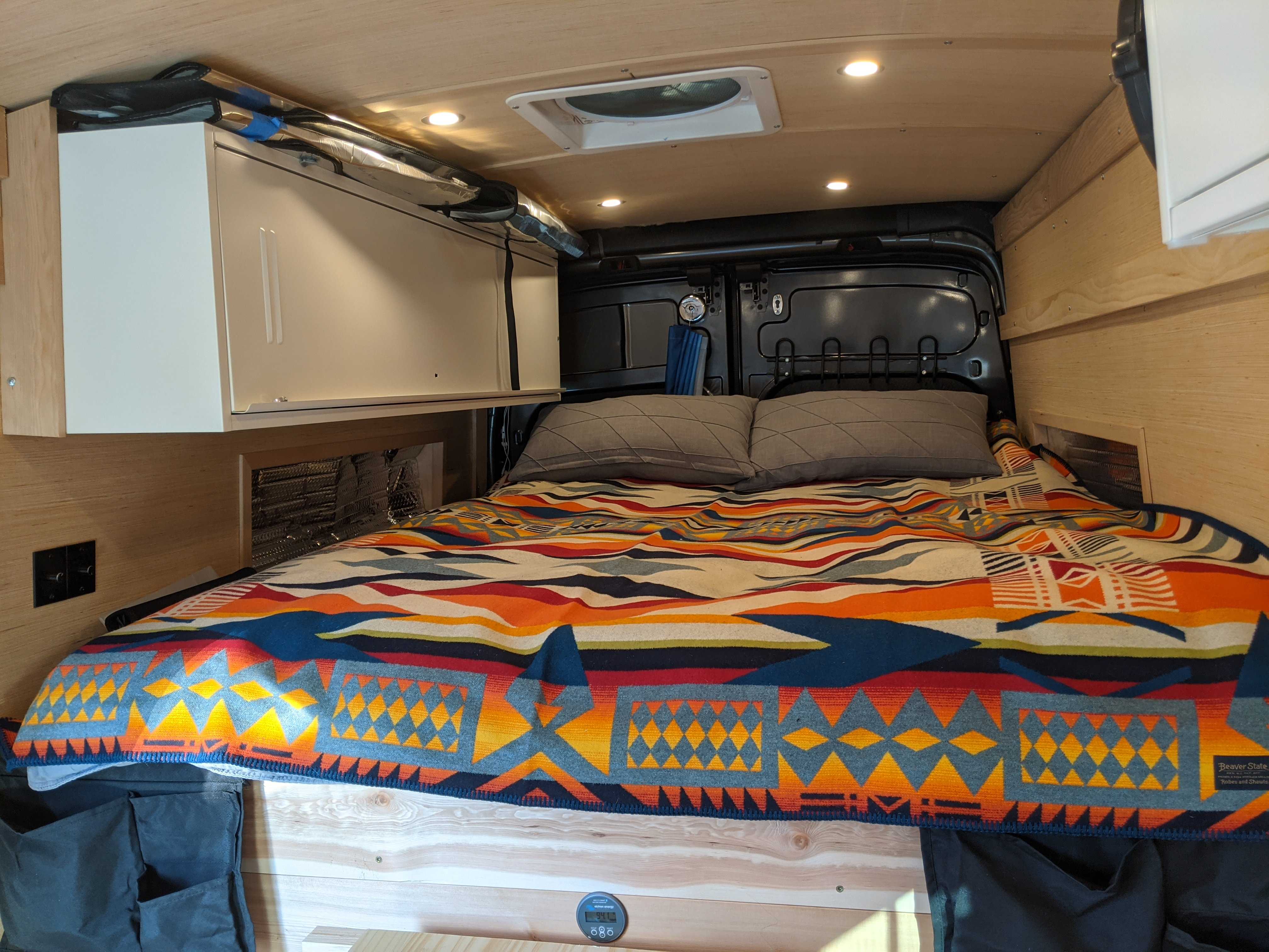 Cozy bed with down comforter and Pendleton blanket. Ford Transit 2017