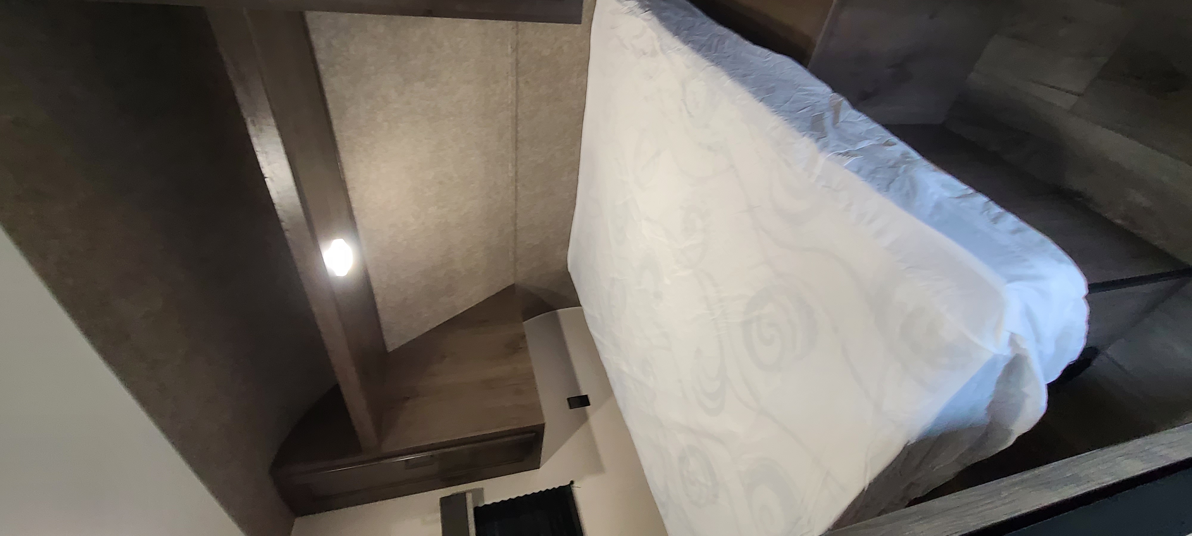 RV rental: Interior view of a white mattress lifted to expose the under-bed storage, a common feature for space-saving.. Open Range 26BHS 2021