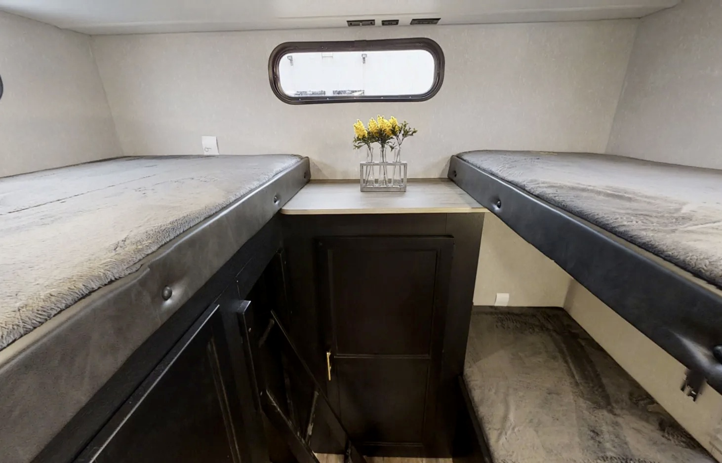 This RV rental offers a compact bunk bed area, complete with upper and lower bunks, a central table, and a window.. Forest River Grey Wolf 29te 2021