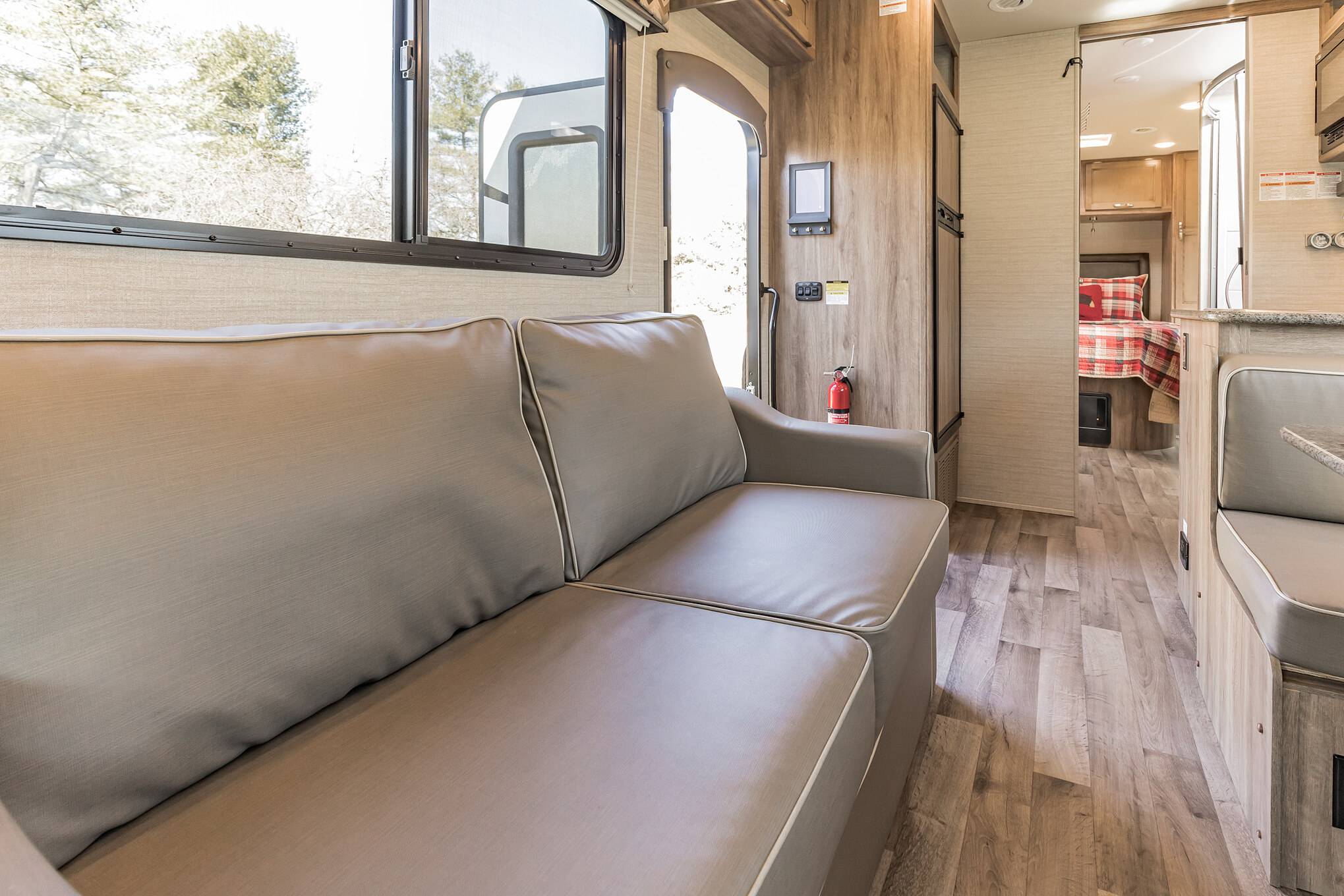 Spacious RV rental interior featuring a comfy sofa, dining area, and a glimpse of the bedroom, perfect for travel adventures.. Jayco Redhawk 2020