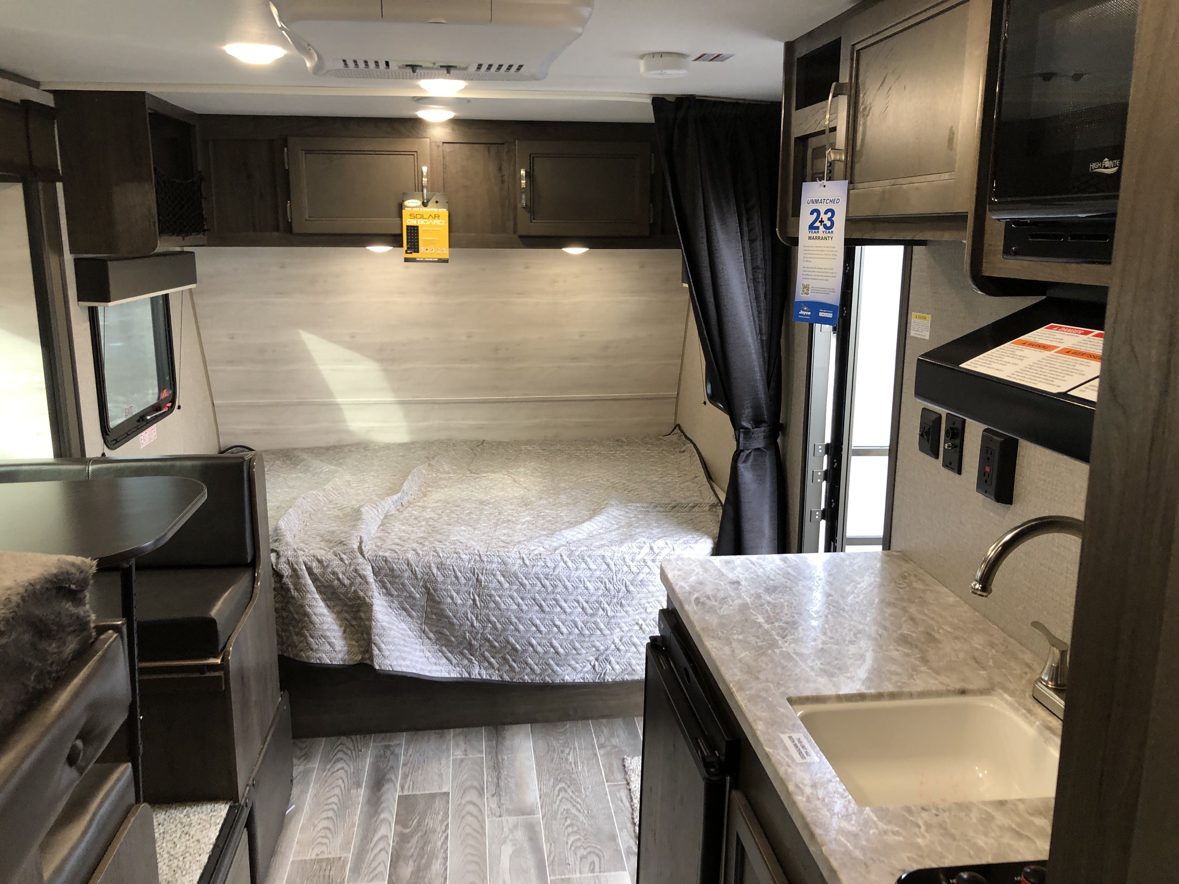 This RV rental offers a cozy interior with a comfortable bed, dining area, and functional kitchen space.. Jayco Jay Flight 2021