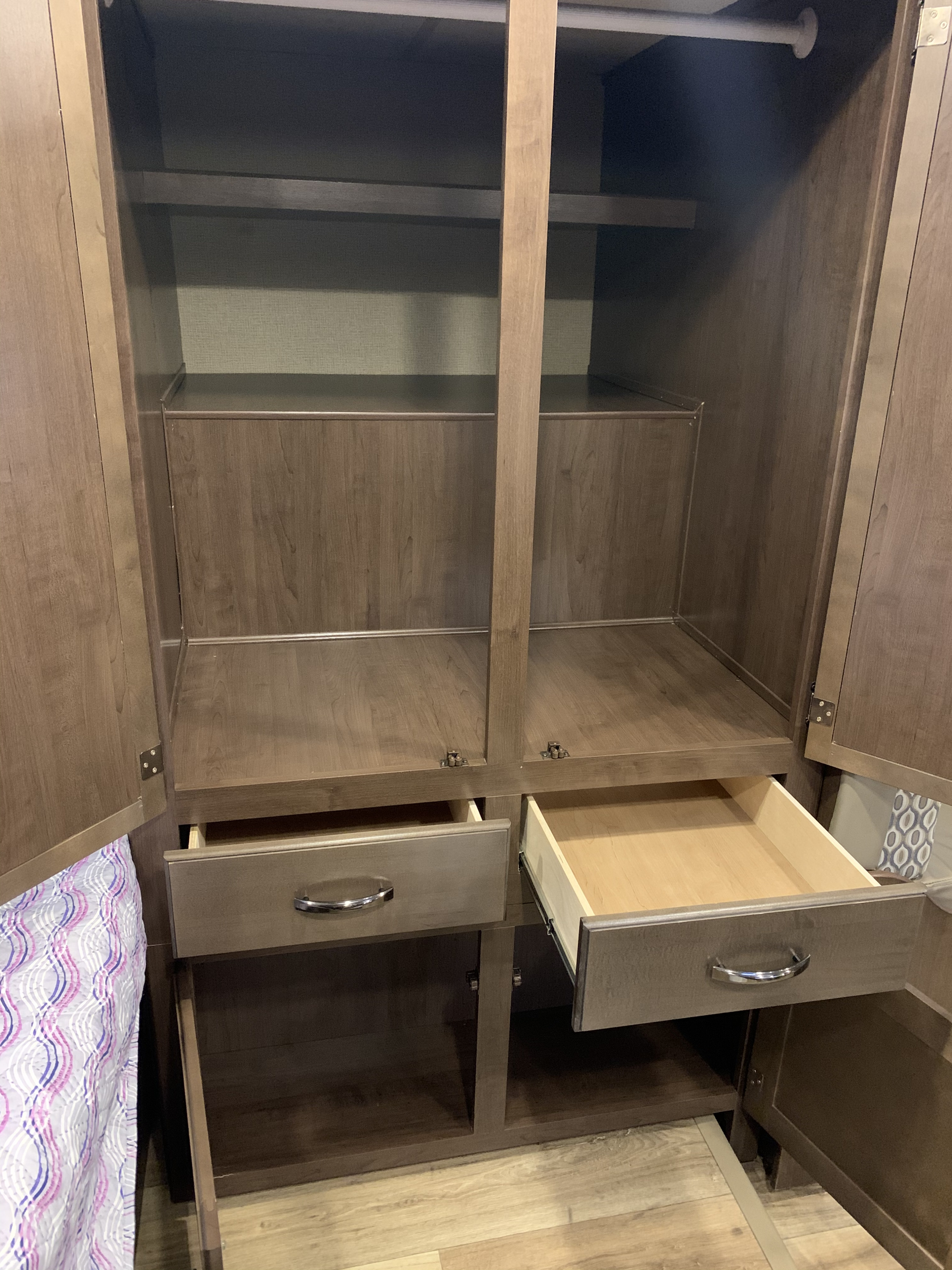 Spacious RV rental closet with shelves, drawers, and hanging space for organized storage in an RV bedroom.. Thor Freedom Elite 2019