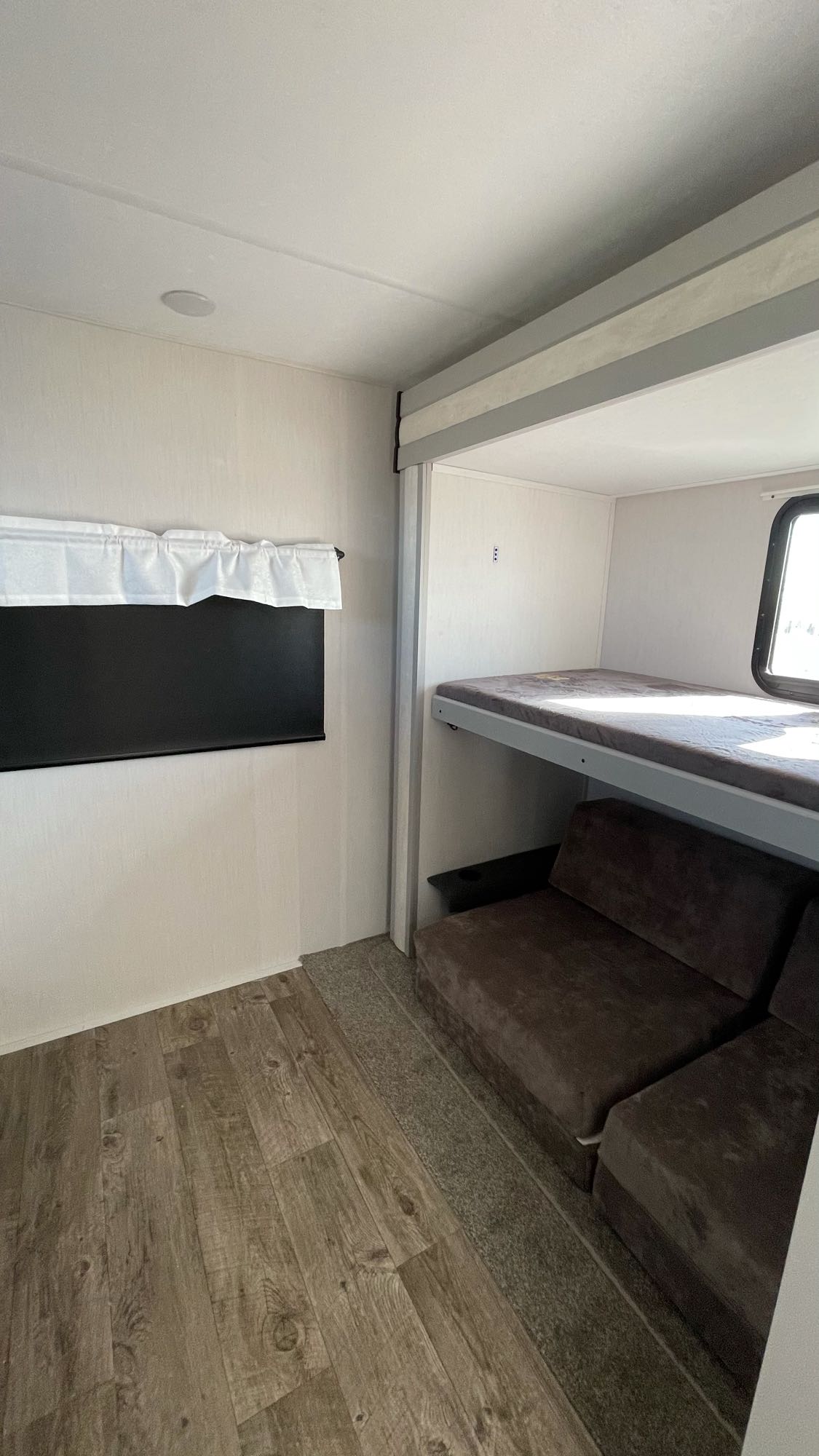 Spacious bunkhouse with a cozy lower sofa bed and upper bunk, showcasing an RV rental interior.. Forest River Vibe 2021