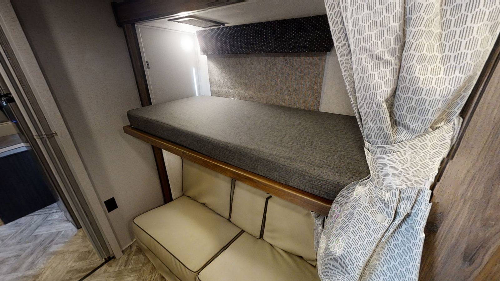 Comfortable RV rental interior with bunk bed, sofa seating, and patterned curtains. Perfect for family trips.. Forest River Forester 2018