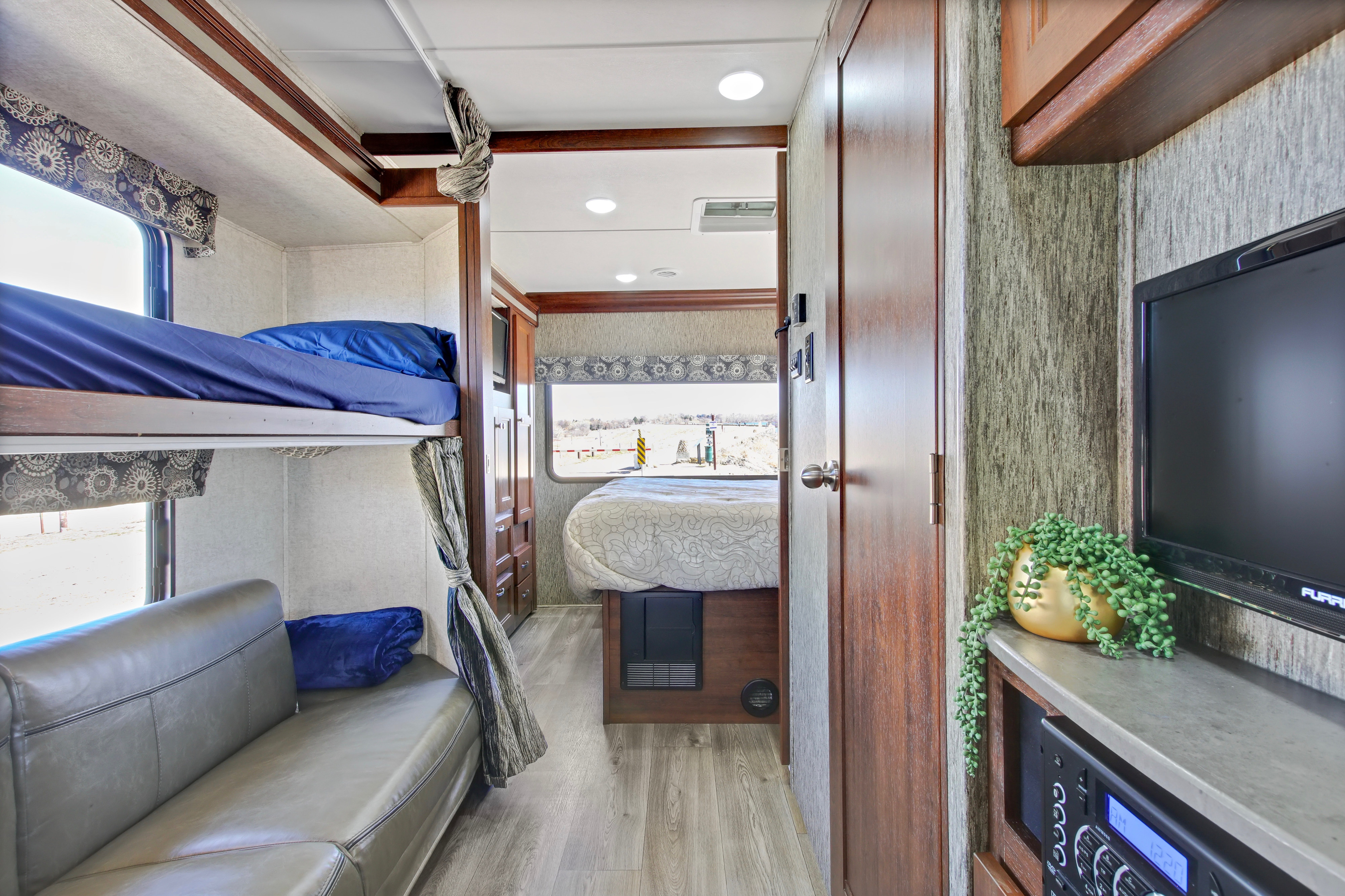 Inside this RV rental: bunk beds, a main sleeping area, and a compact living space with entertainment.. Forest River Sunseeker 2018