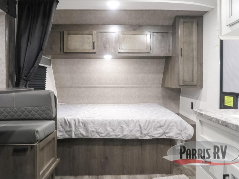 Cozy RV rental interior featuring a comfortable bed, ample overhead storage, and a practical dinette area for living and dining.. Highland Ridge RV Open Range 2021