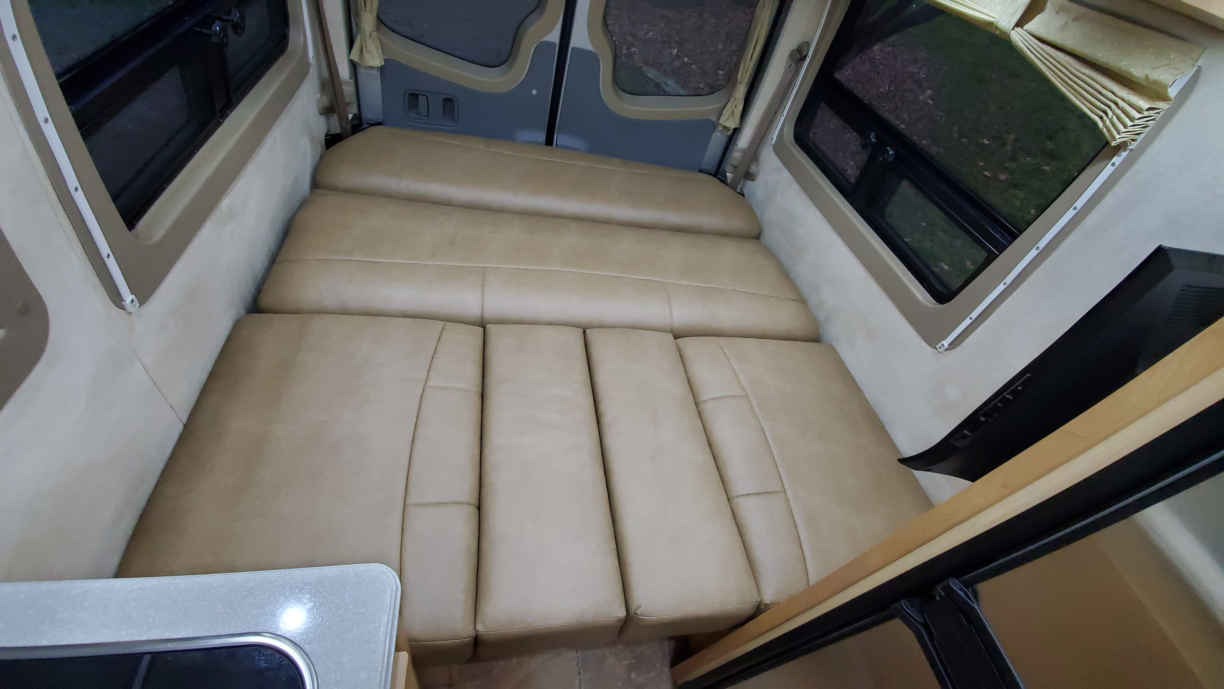 Spacious RV rental interior featuring a comfy convertible bed/seating area and large windows, perfect for travel.. Pleasure Way Plateau Ts 2013