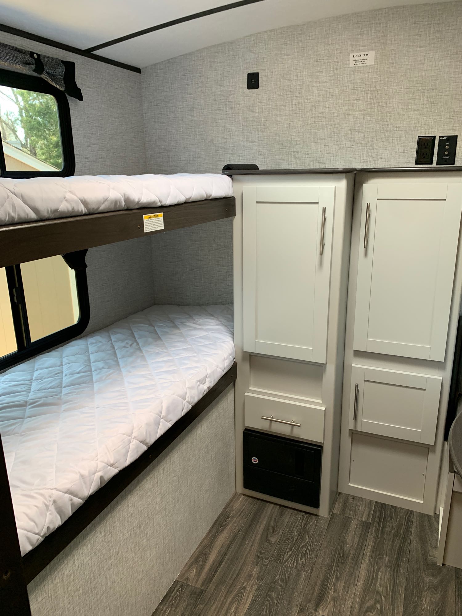 Modern RV rental interior featuring comfortable bunk beds and storage cabinets, ideal for family travel.. Keystone RV Bullet Ultra Lite 2021