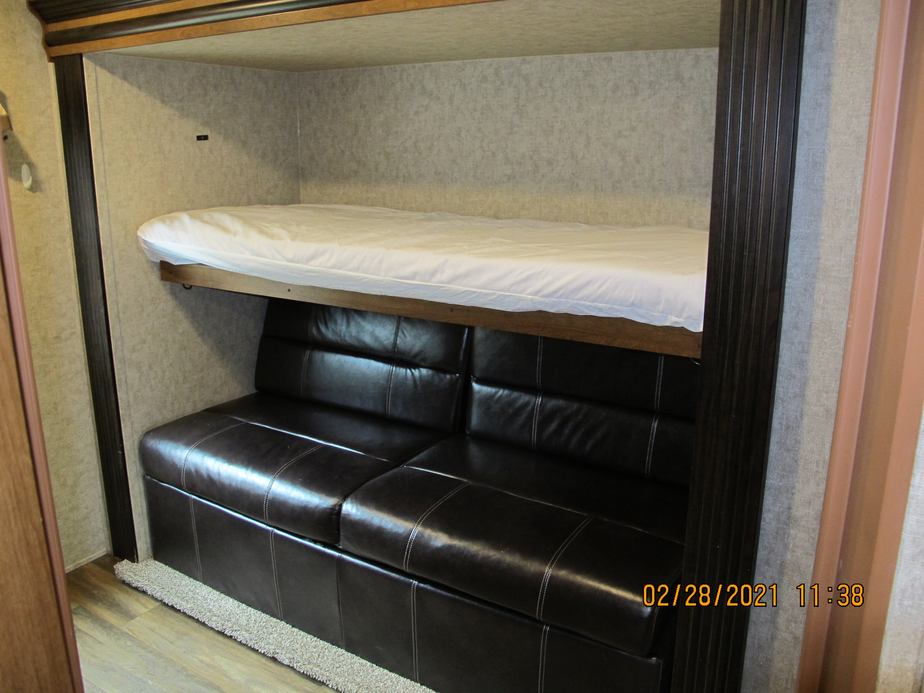 This RV rental interior offers a bunk bed above a dark sofa, providing extra sleeping space and comfort.. Other Lacrosse 2017