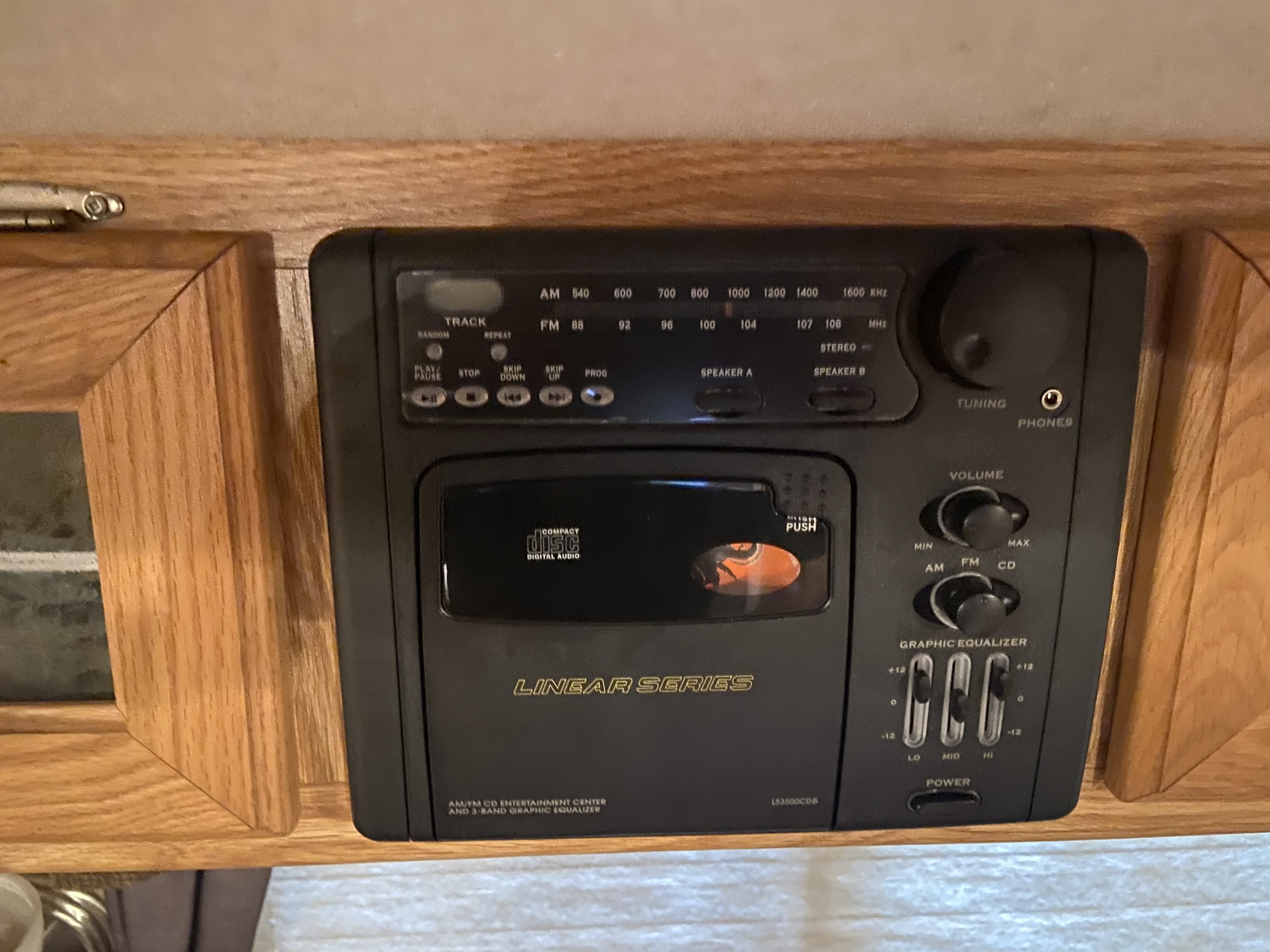 A black AM/FM CD stereo system with graphic equalizer controls, integrated into wood, ideal for an rv rental.. Okanagan Eclipse 2005