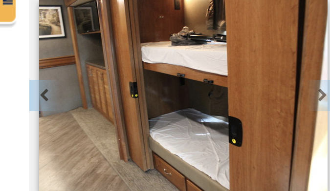 RV rental interior showcasing bunk beds with white sheets, providing compact sleeping space for your next adventure.. Fleetwood Pace Arrow 2018