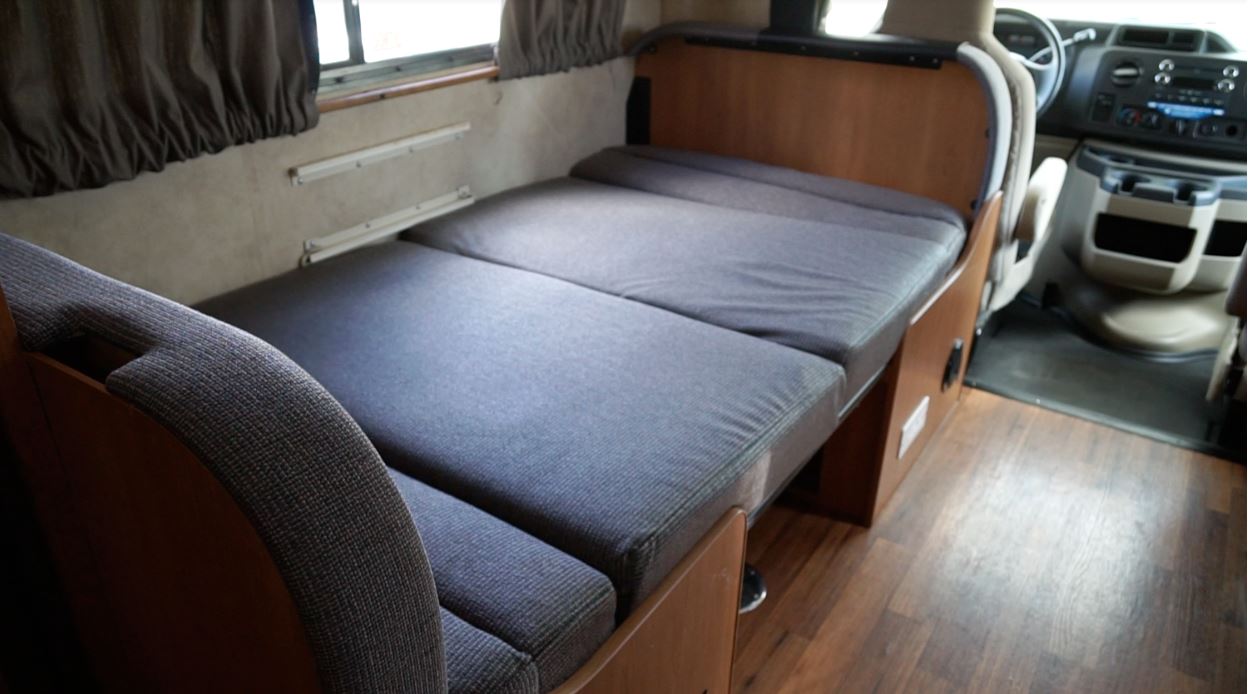 Cozy RV rental interior featuring a grey convertible bed.. Thor Motor Coach Four Winds Majestic 2013