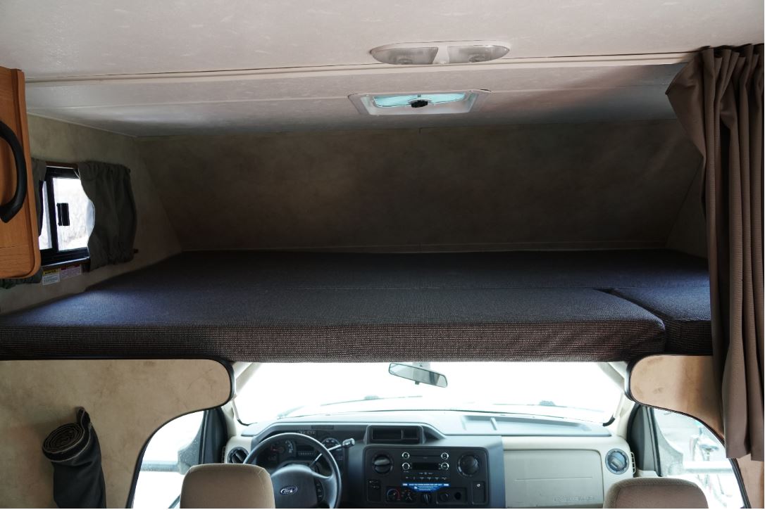 RV rental interior showing the cab-over bunk bed with mattress and ceiling vent.. Thor Motor Coach Four Winds Majestic 2013