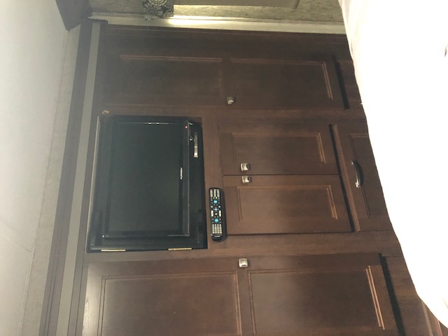 RV rental: Dark wood cabinets, small TV, and remote offer compact entertainment & storage.. Forest River Sunseeker 2017