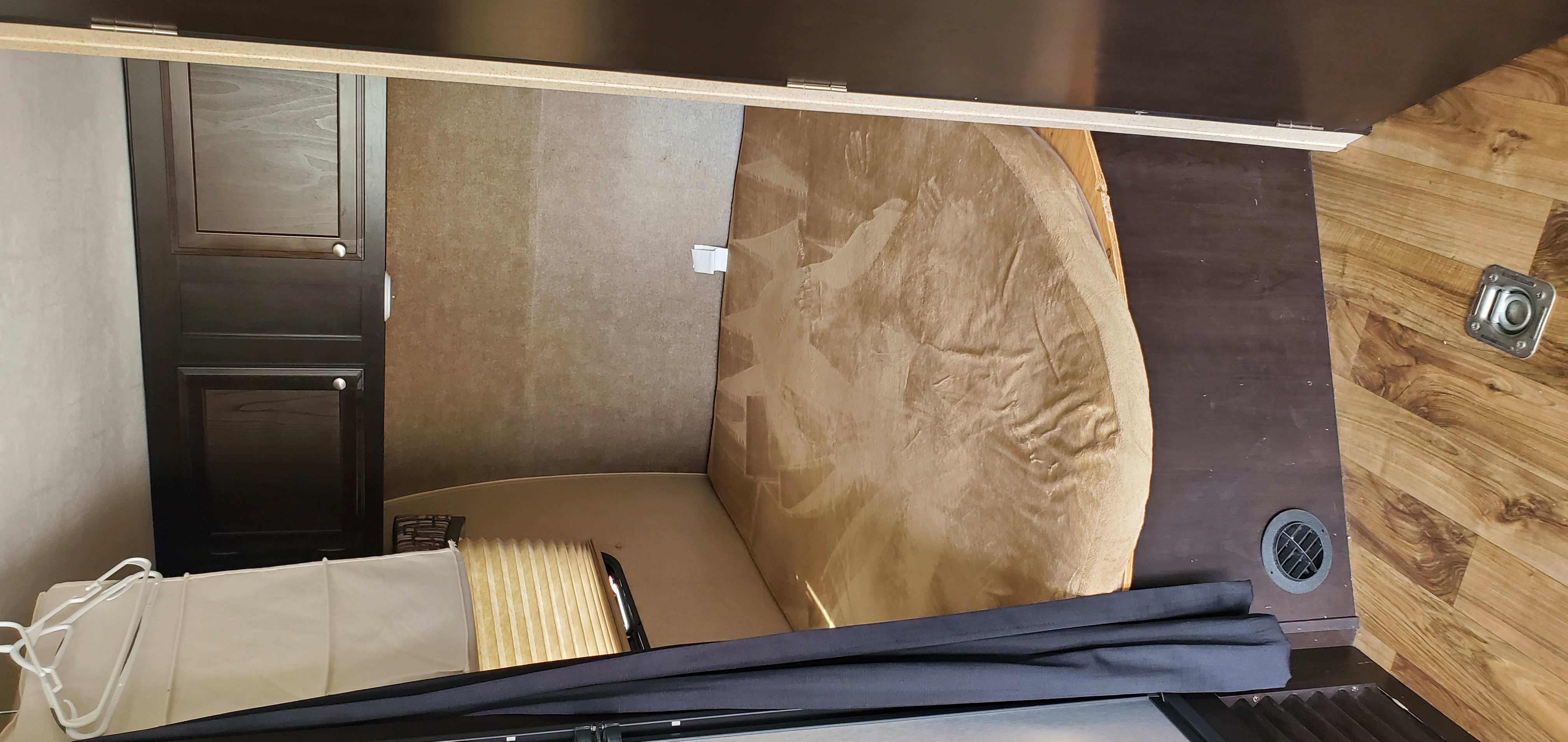 This RV rental offers a bed with a textured cover, dark wood cabinets, wood-look floor, and cargo tie-down.. Jayco Octane 2016