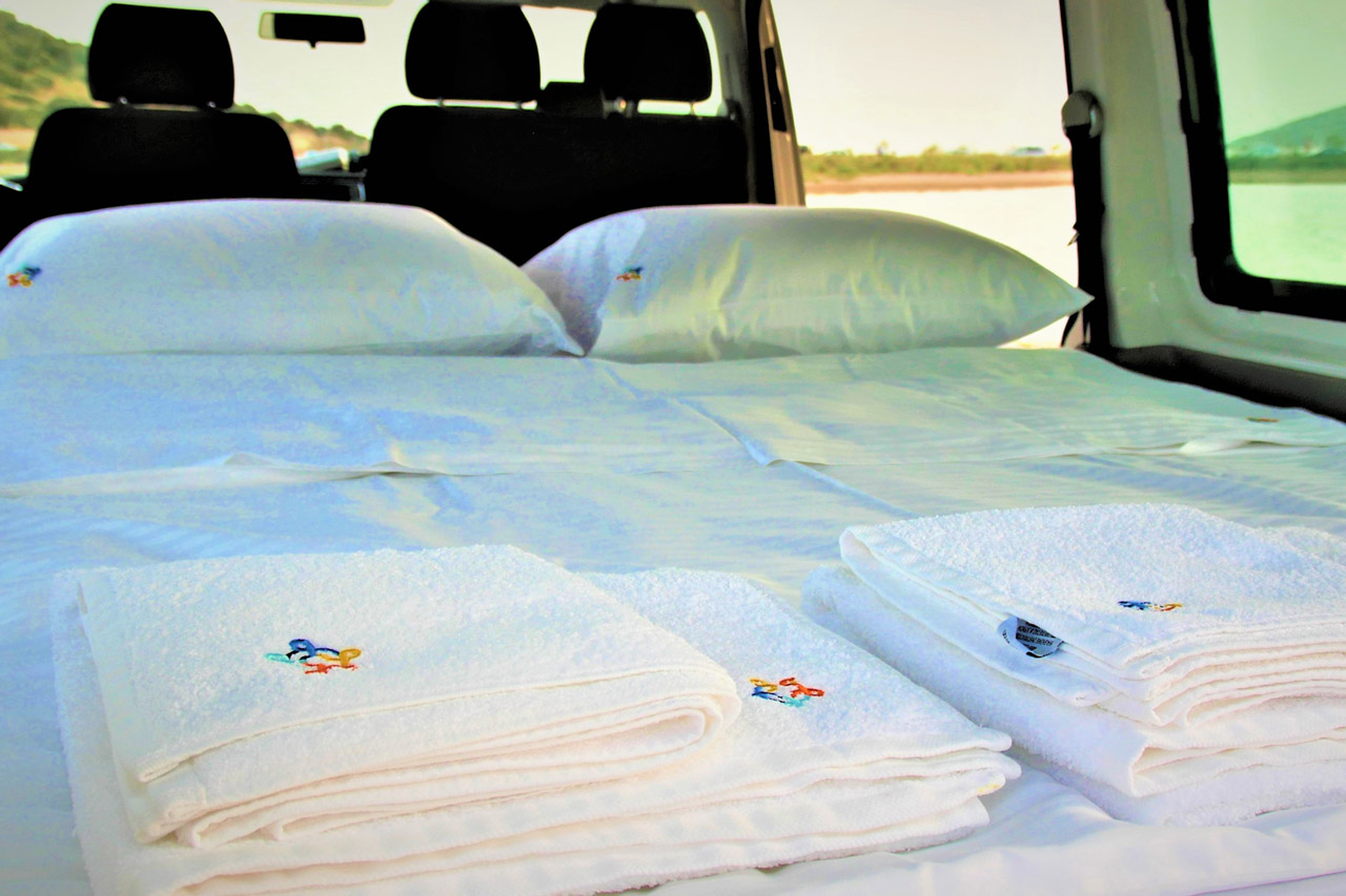 Cozy RV rental setup: a comfortable bed with pillows & fresh towels, ready for your mobile adventure.. Volkswagen T6 2020
