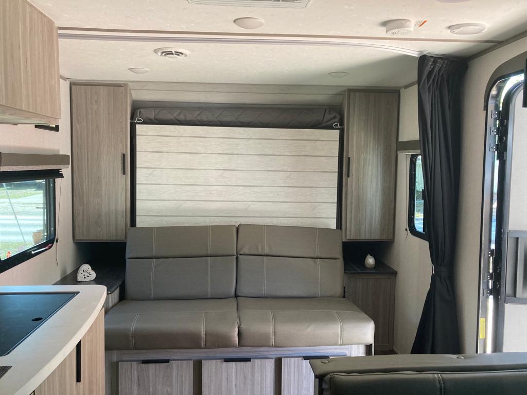 Spacious RV rental interior with a modern sofa, ample storage, and kitchen amenities. Ready for your adventure.. Keystone RV Passport SL 2021