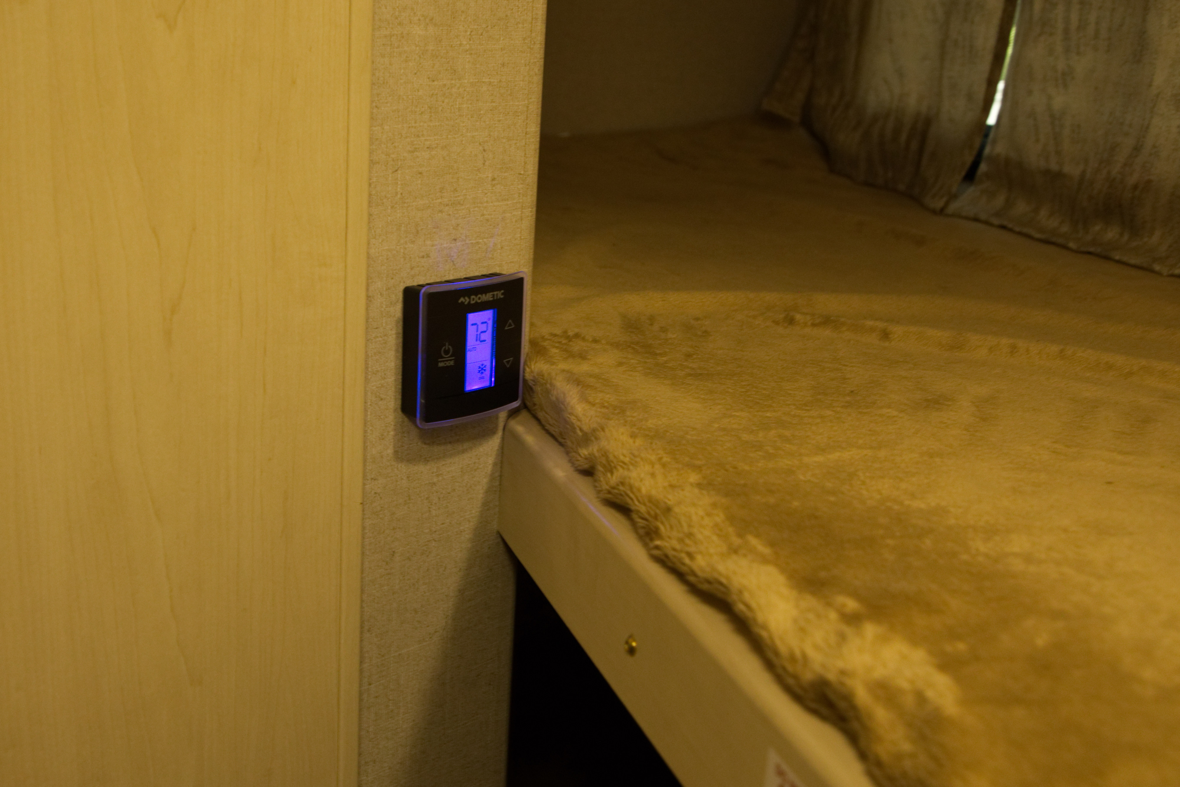 RV rental interior featuring a Dometic thermostat set to 72 degrees, next to a cozy bunk bed with a fuzzy blanket.. Other Other 2019