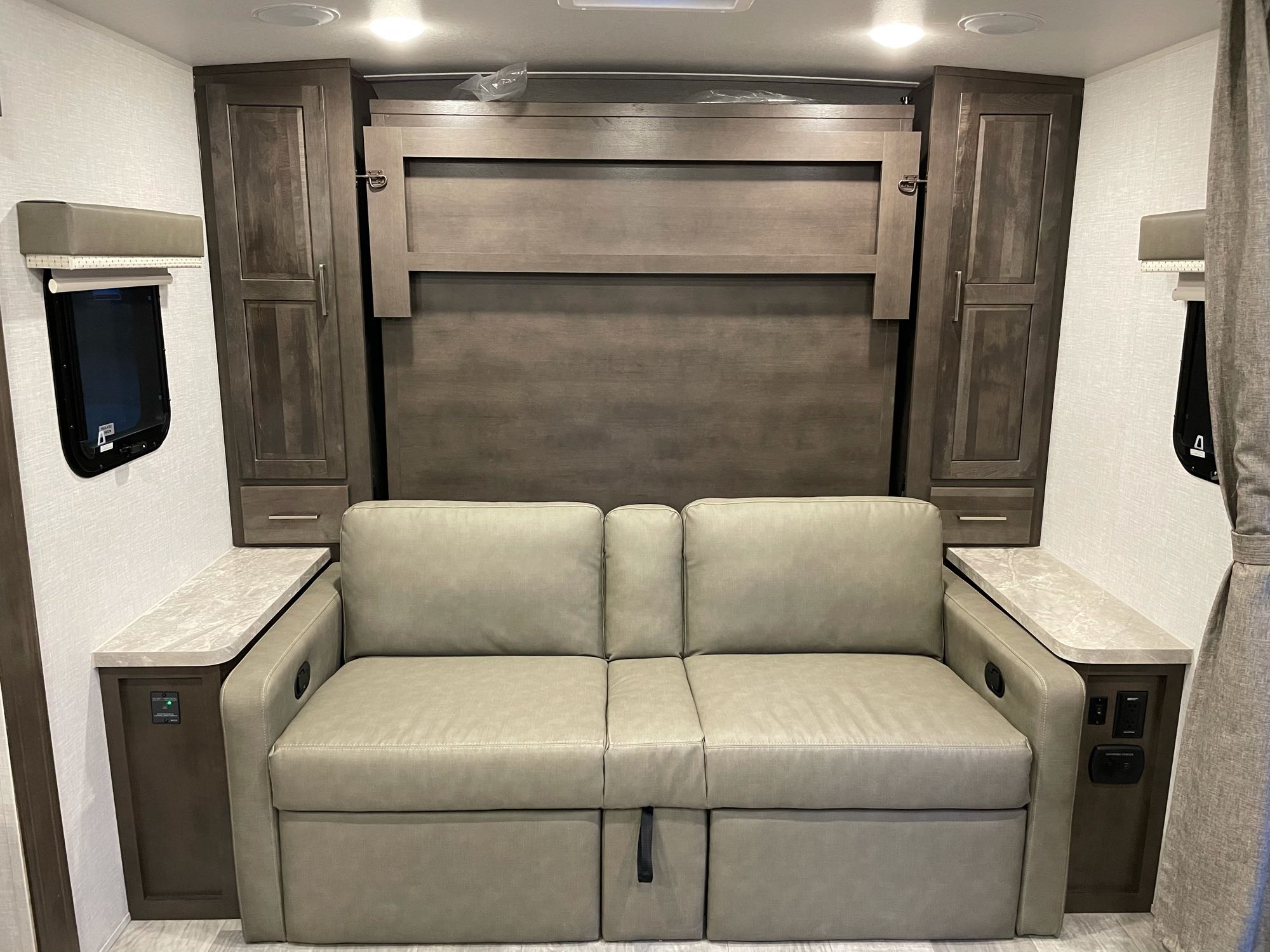 Comfortable RV rental interior featuring a versatile sofa, murphy bed, and storage. Perfect for compact living.. Forest River Mini-Lite 2021