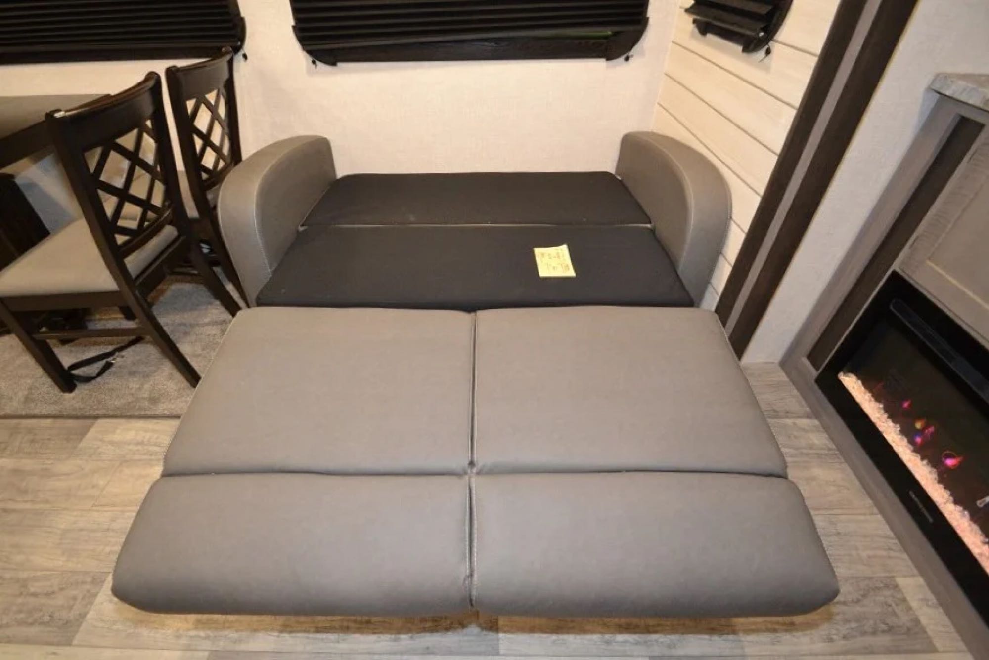 RV rental interior: Sofa converted to bed, with dining chairs & fireplace, showing compact living space.. Crossroads Other 2021