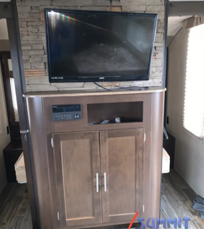 Cozy RV rental interior: flat-screen TV above an entertainment center with stereo and storage cabinets.. Forest River Cherokee Grey Wolf - 29BH 2017