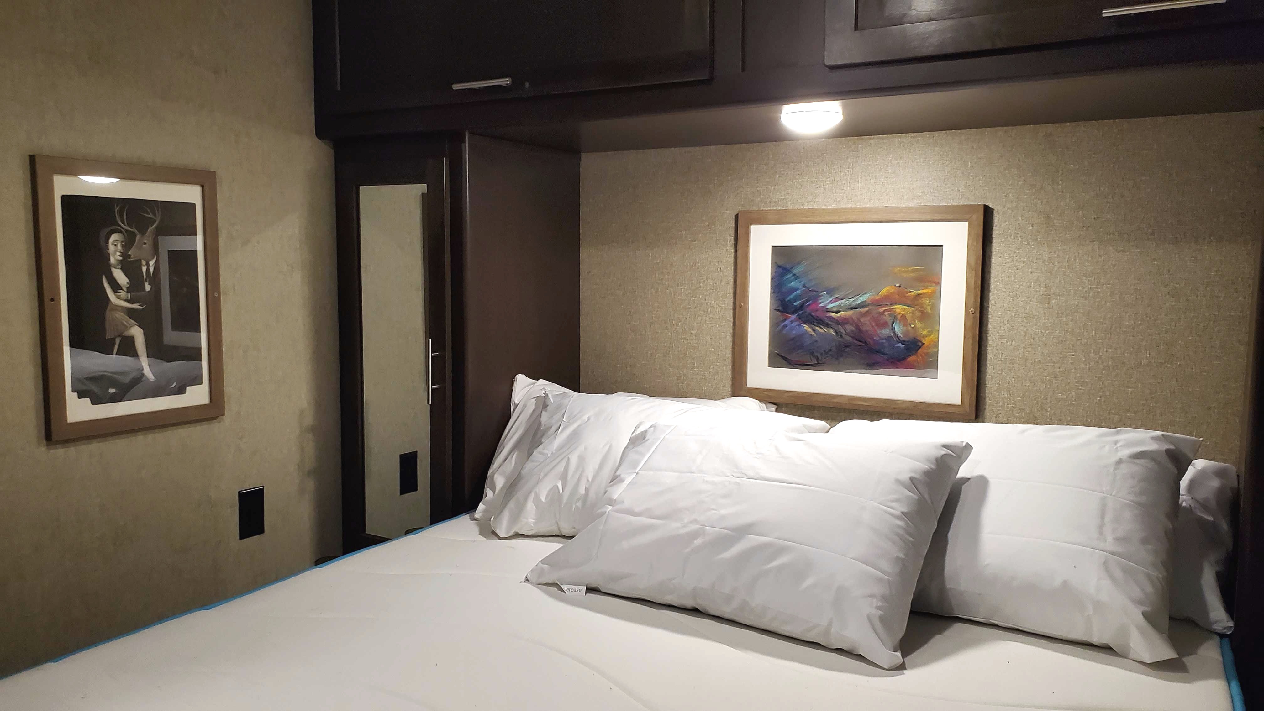 RV rental bedroom with white pillows, built-in storage, and unique wall art.. Forest River Cherokee VFK Limited 2017