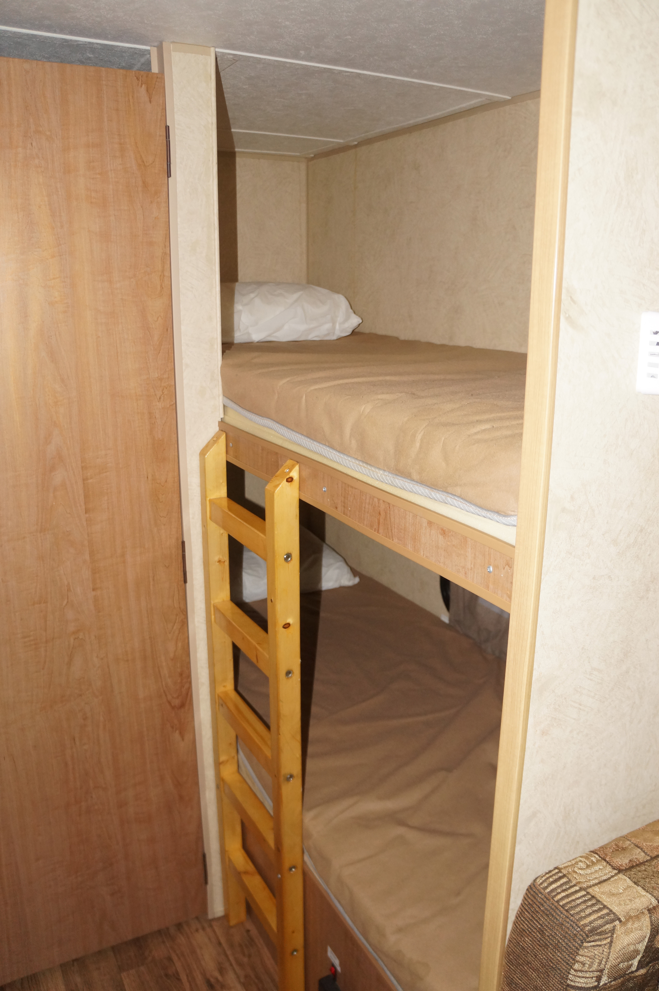 RV rental interior: Two stacked bunk beds with a wooden ladder, optimizing space for sleeping.. Skyline Nomad 2013