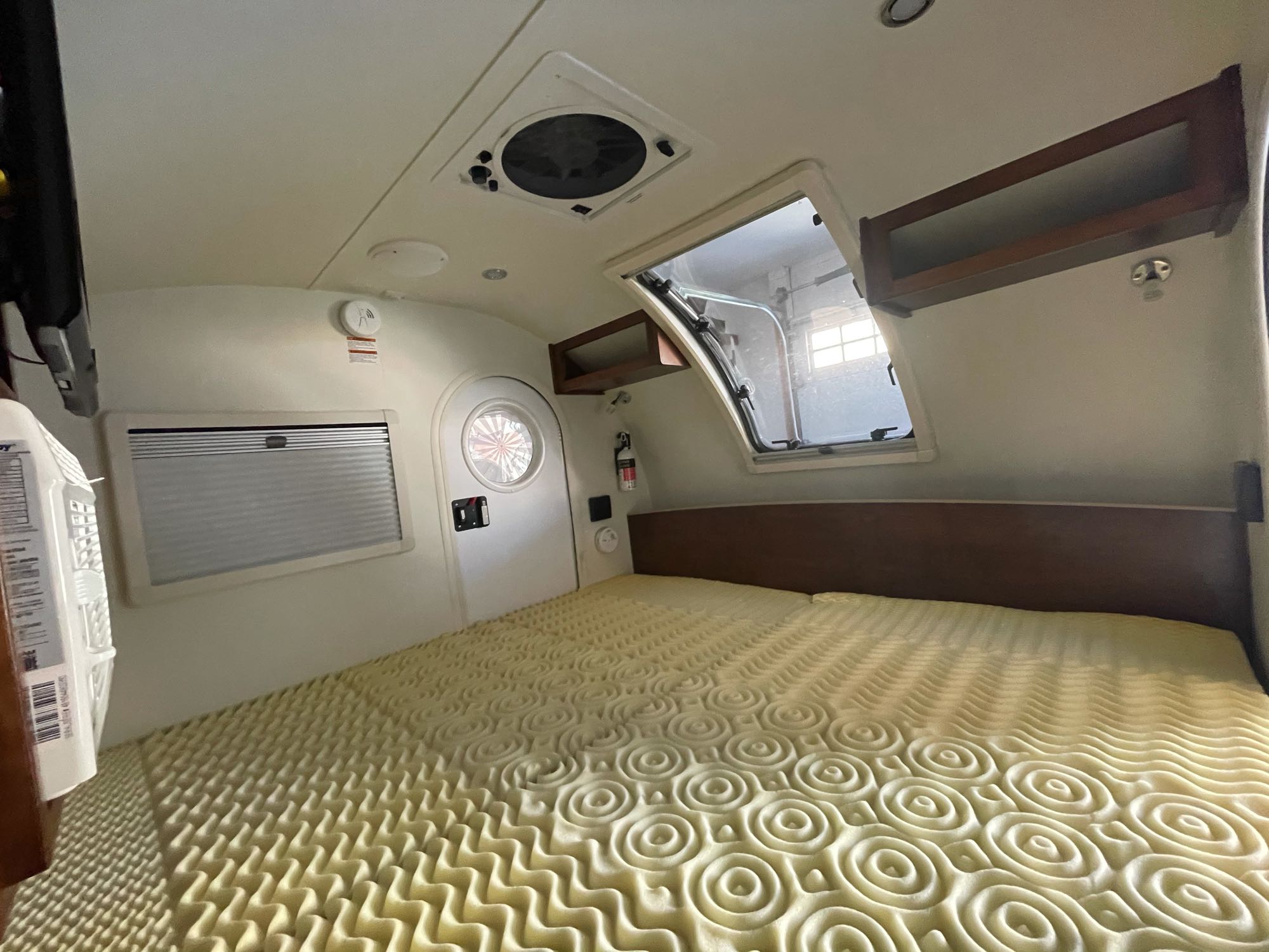 Compact & cozy RV rental interior: spacious bed, ceiling fan, overhead storage, ready for adventure.. T@G XL 2017