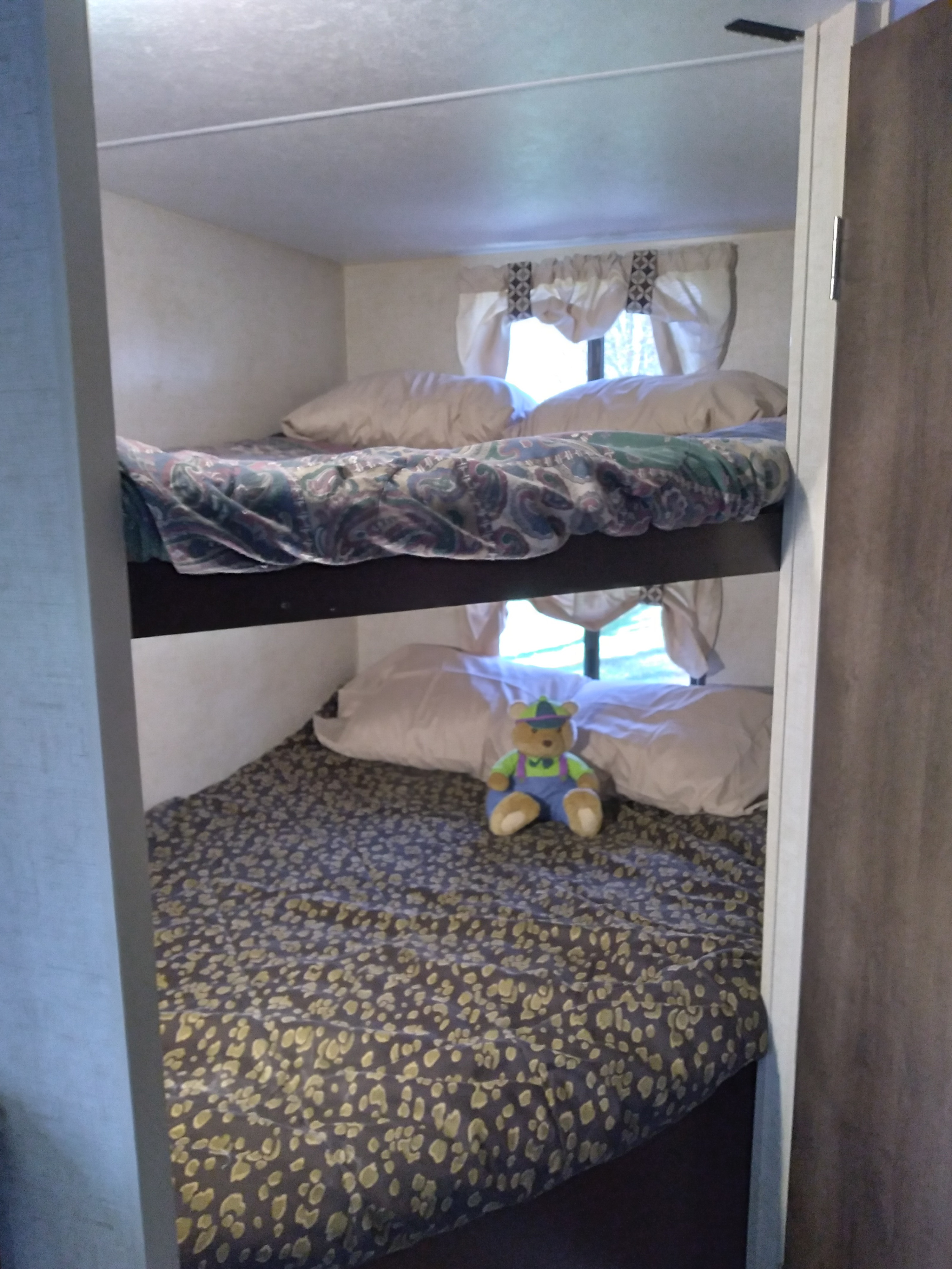 Cozy RV rental bunk beds offer comfortable sleeping for travel, with a cute teddy bear on the bottom bunk.. KZ Other 2017