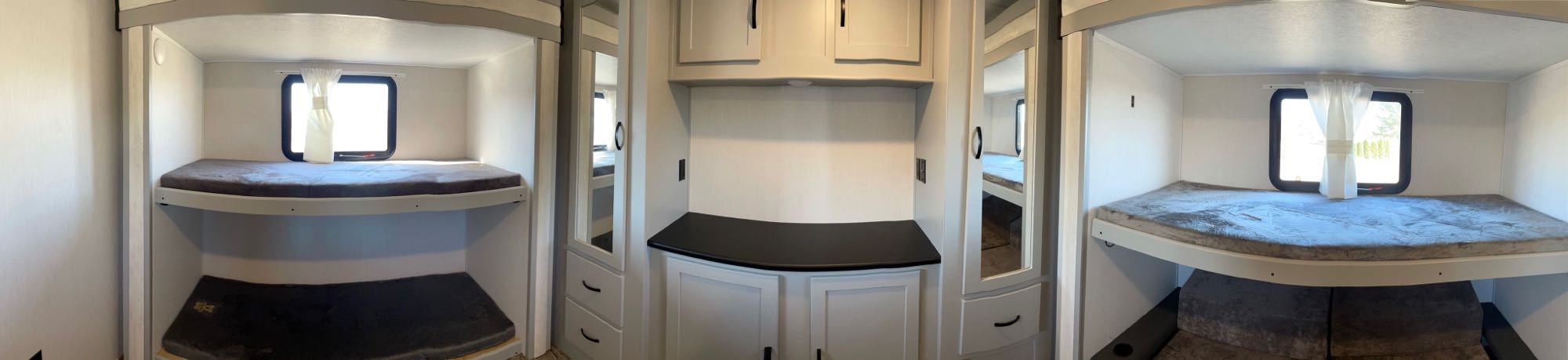 Cozy bunk beds and storage in this RV rental's interior, featuring light walls and functional space for travelers.. Forest River Vibe 2021