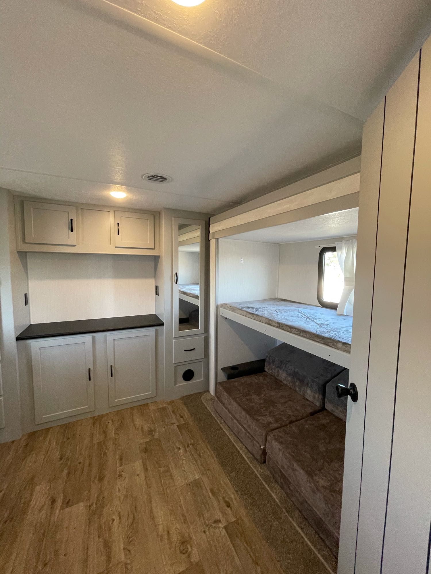 Spacious modern RV rental interior featuring bunk beds, cabinet storage, and light-colored walls for a comfortable stay.. Forest River Vibe 2021