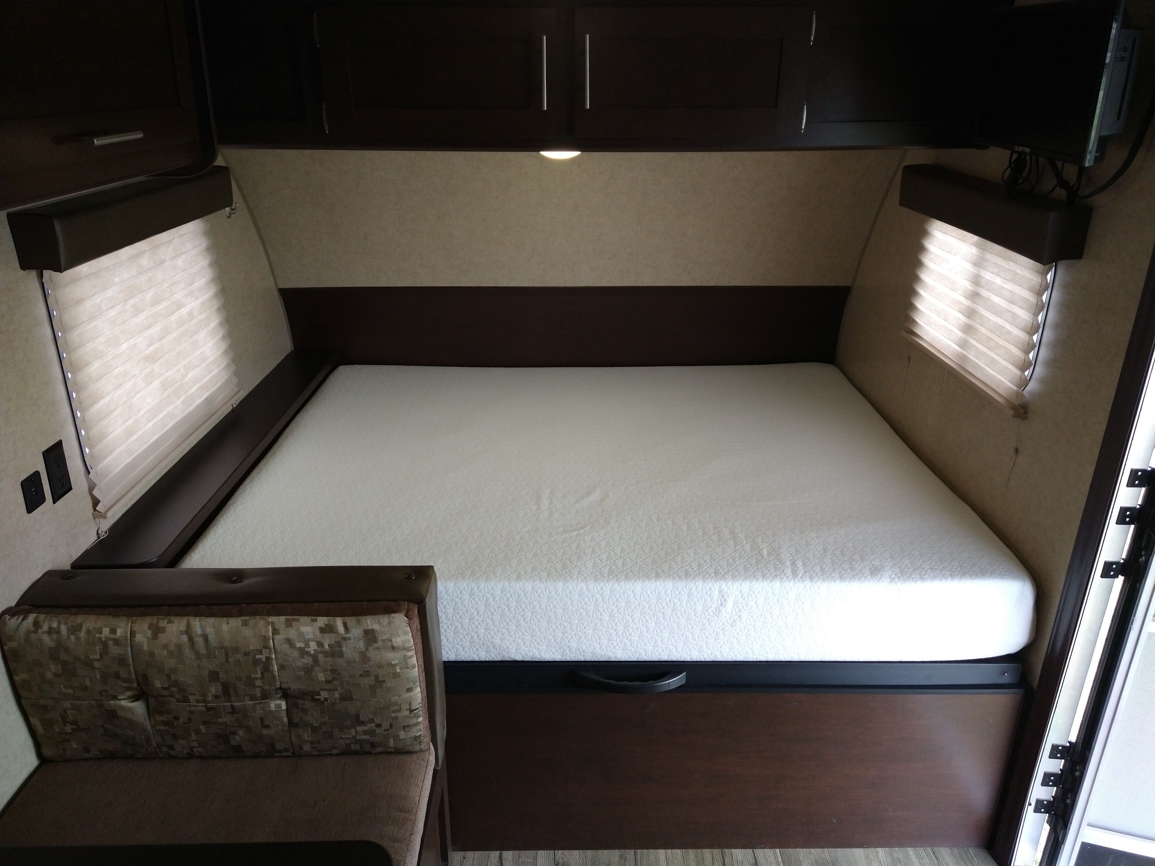 Clean RV rental bedroom with white mattress, overhead cabinets, and window blinds. Ready for your next adventure.. Forest River Cherokee Wolf Pup 2017